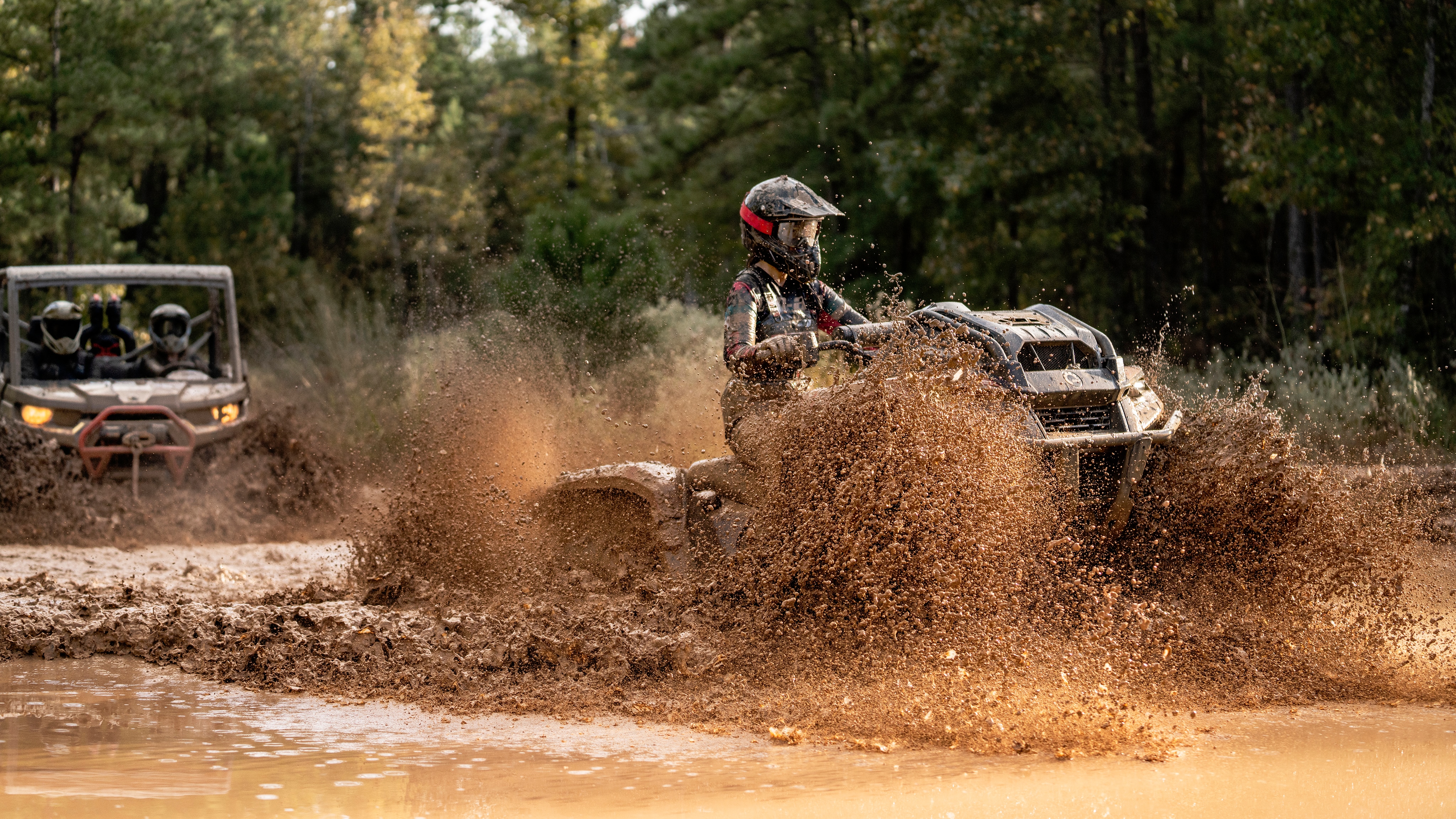 An ATV and a side-by-side in the mud