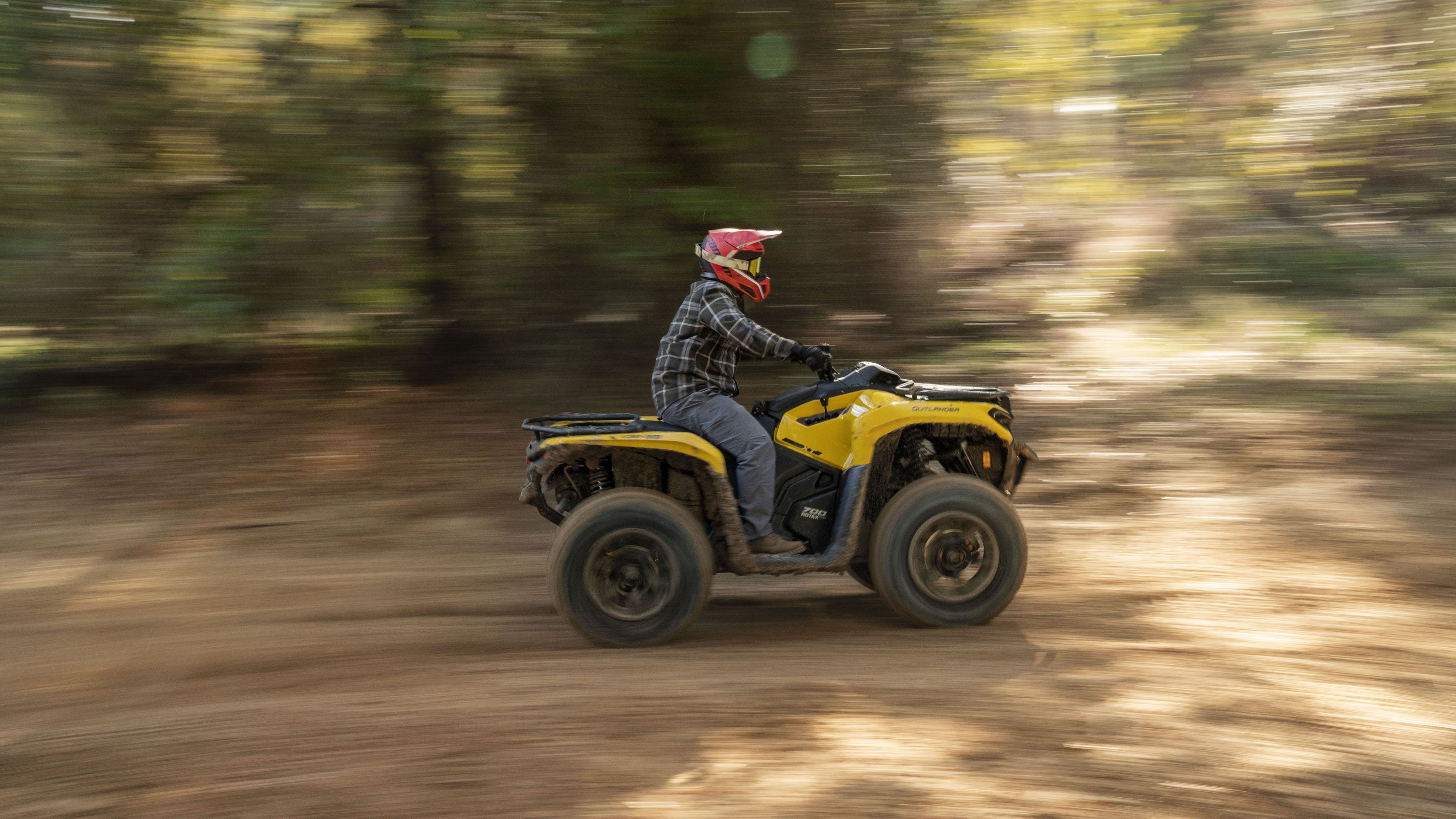 A Neo Yellow Can-Am Outlander XT 700 driving in a blurred setting