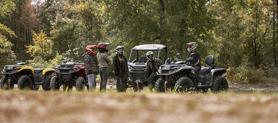 Group of riders next to Can-Am Outlander and Can-Am Defender
