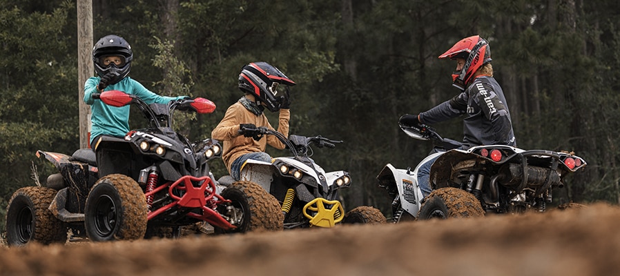 Young riders on their Can-Am Renegade EFI watched by an adult 