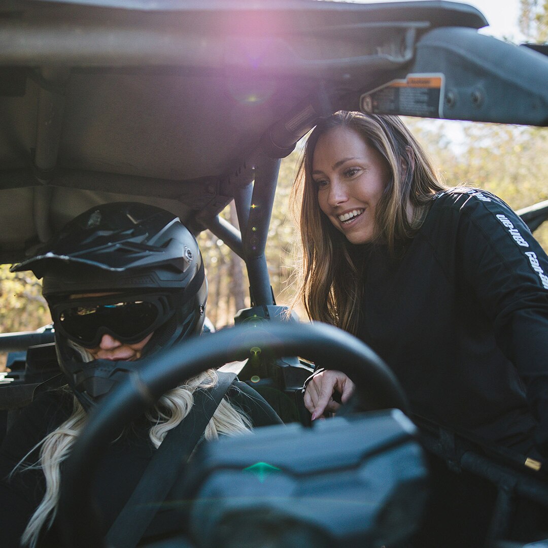 Woman chatting with a friend before setting off in her Can-Am Côte-à-Côte