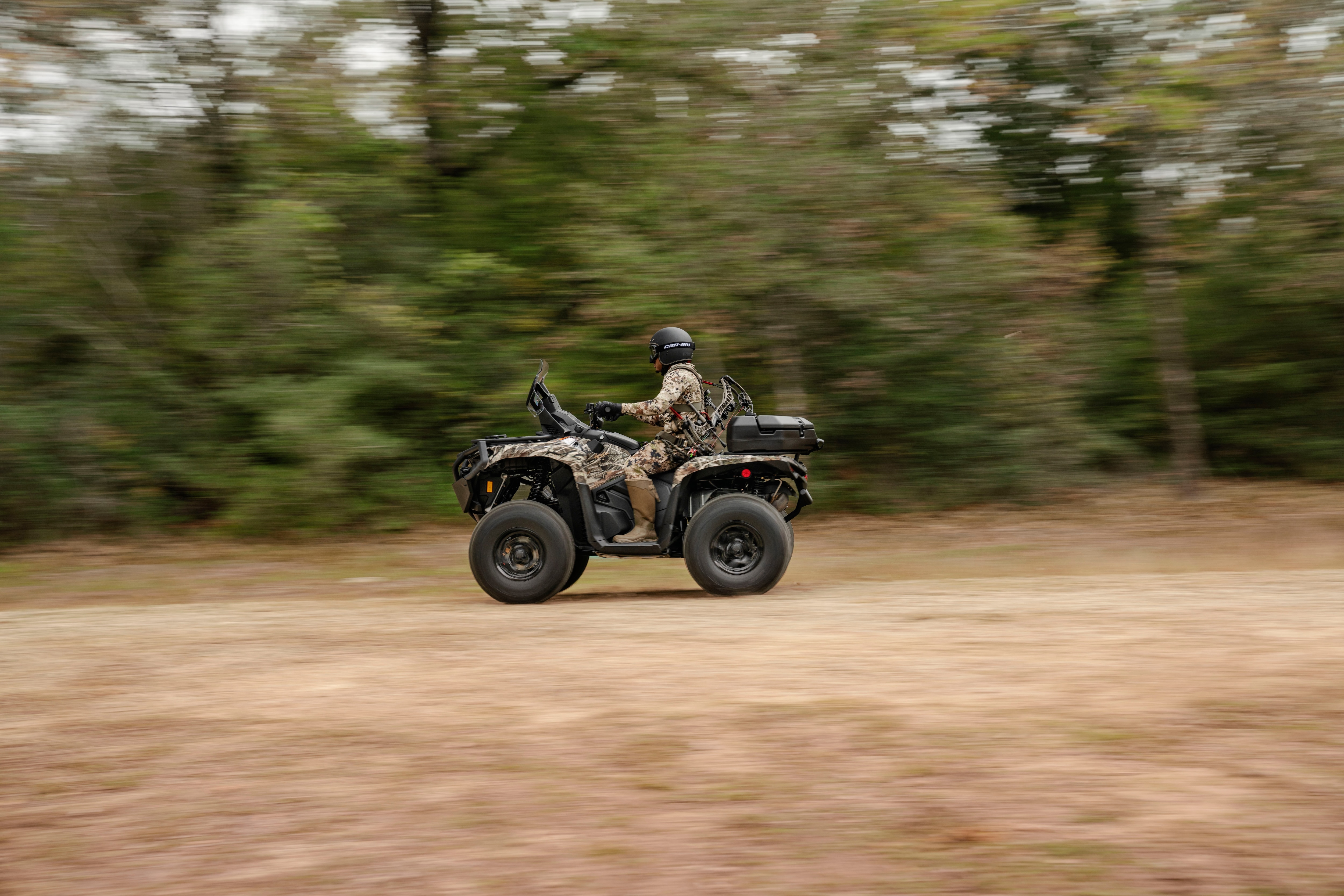 A hunter on his Can-Am Outlander PRO Hunting Edition driving through the forest