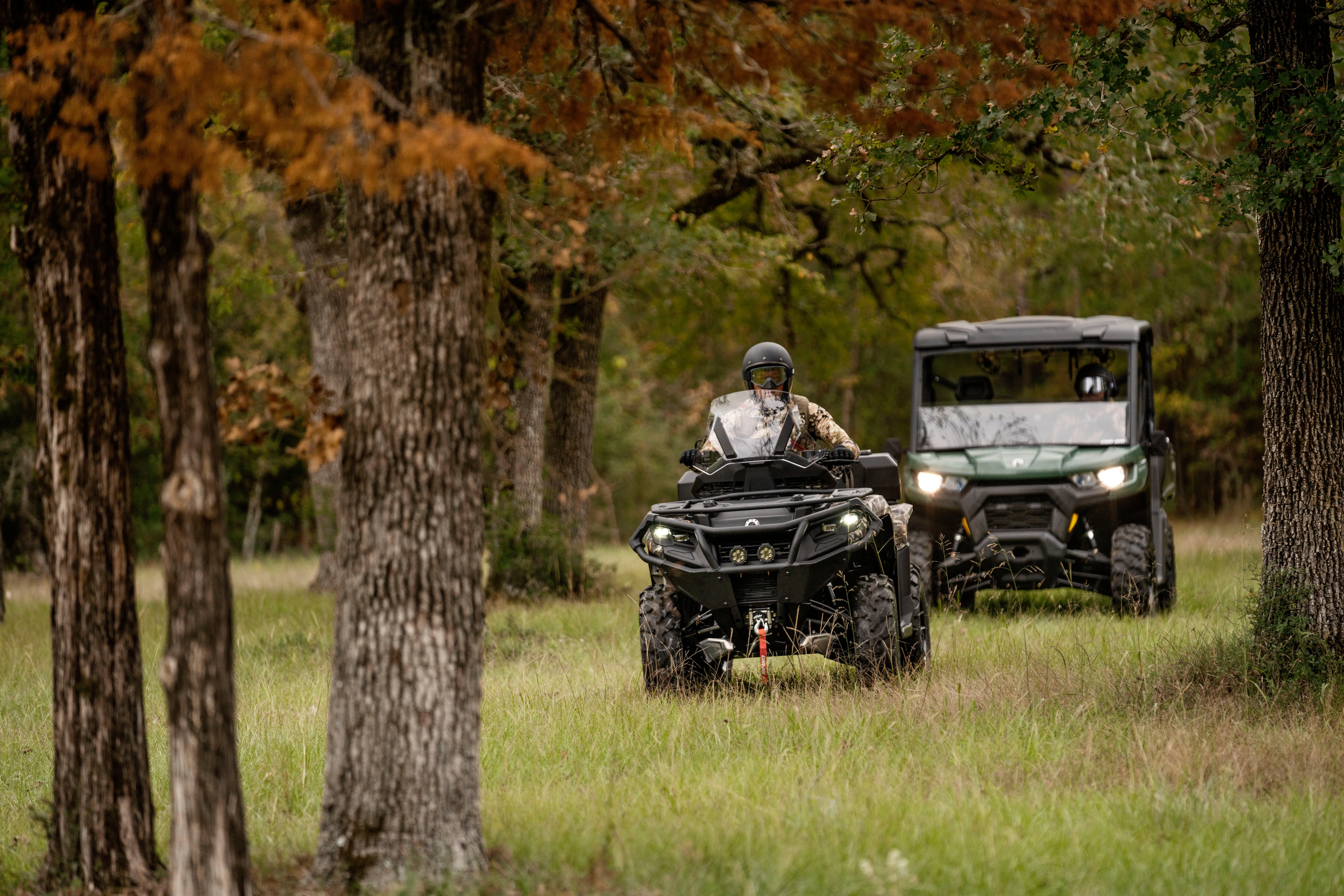 A Can-Am Defender driving behind a Can-Am Outlander PRO Hunting Edition on a hunt