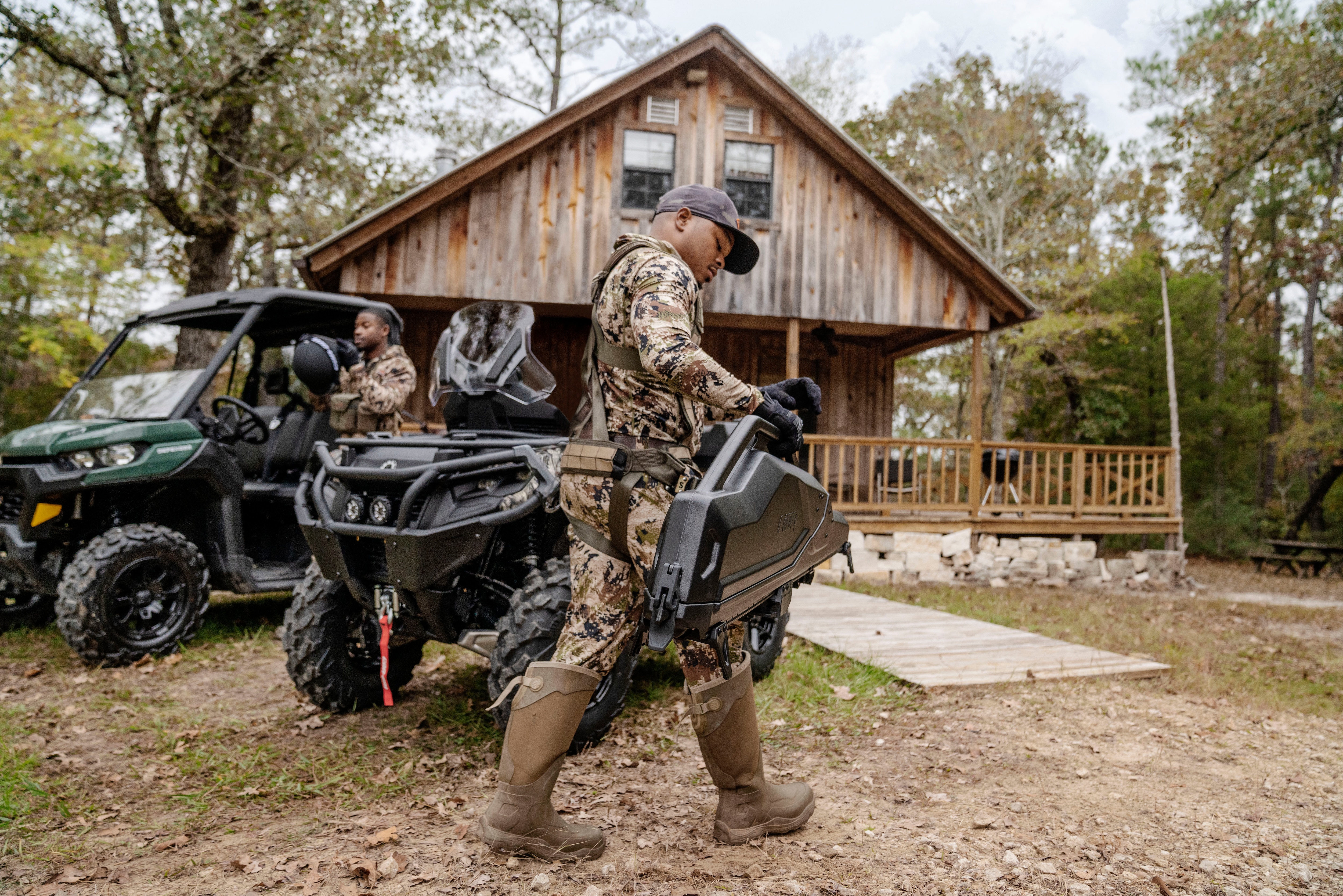 Two hunters loading their Can-Am Defender and Outlander PRO Hunting Edition for a day of hunting