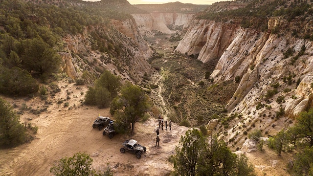 An aerial view of a desert canyon with several drivers and side-by-side Can-Am vehicles