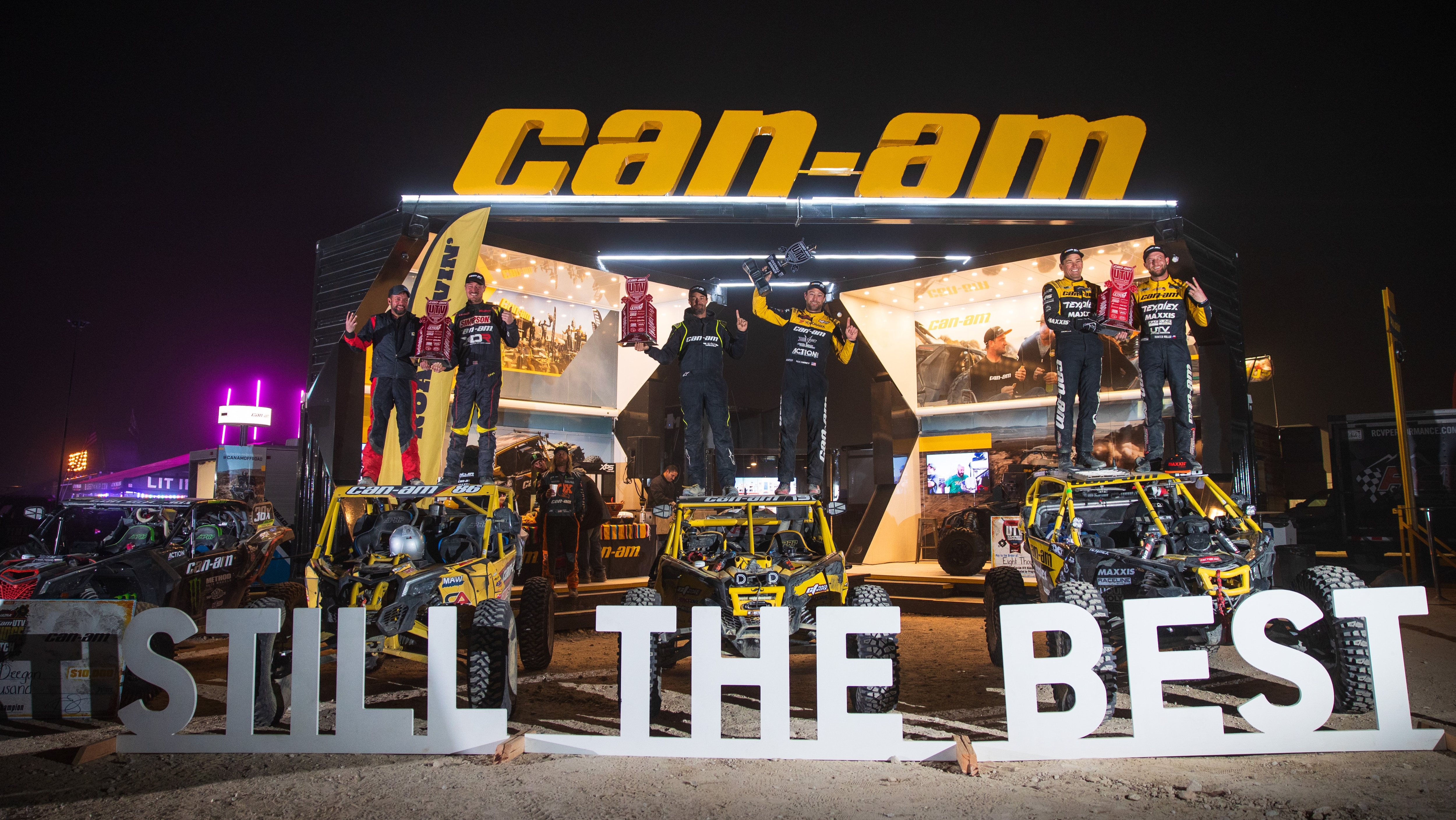 Can-Am racers standing on top of their Maverick X3 after sweeping the podium at the King of Hammers race. 