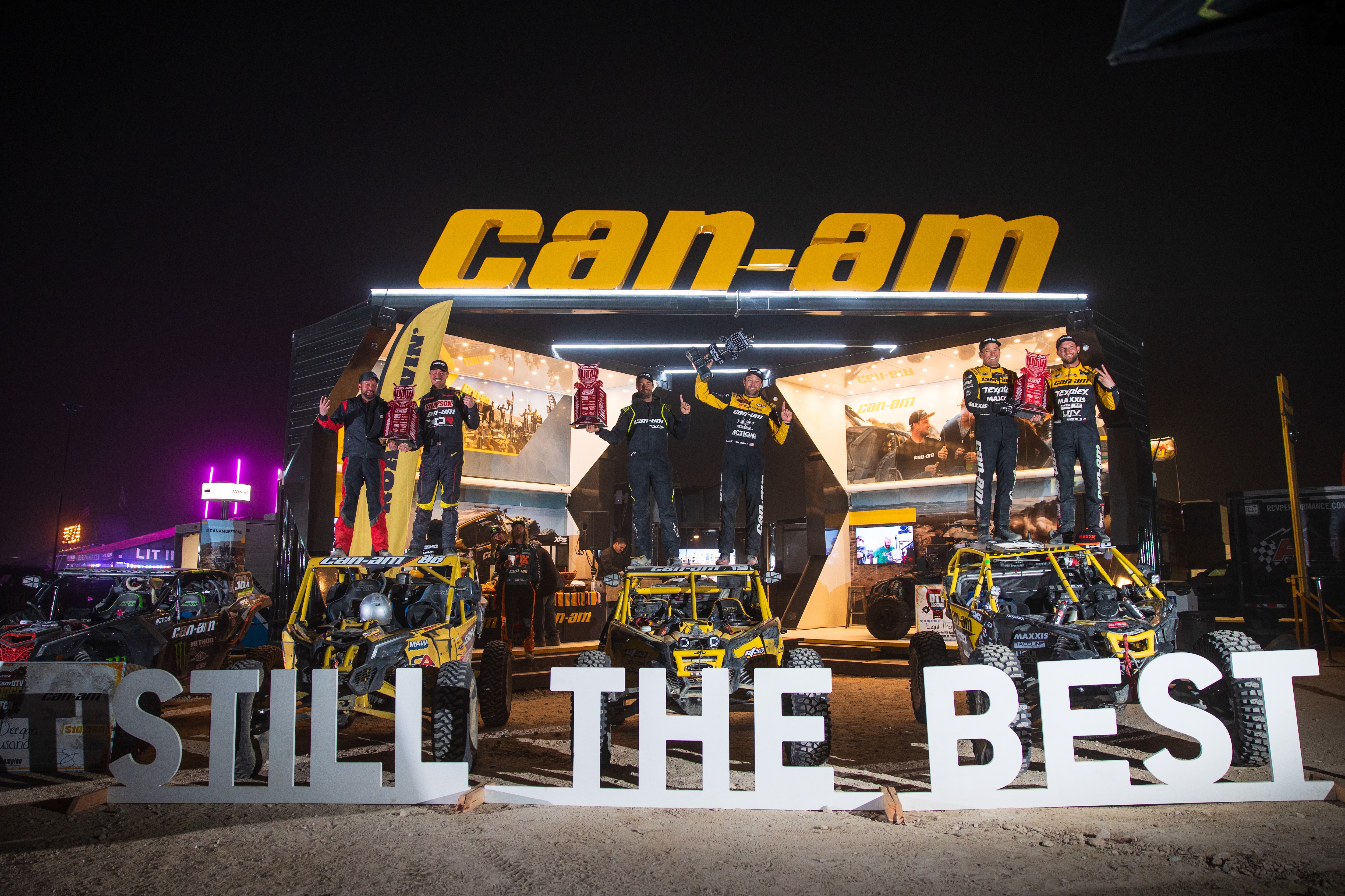 Can-Am racers standing on top of their Maverick X3 after sweeping the podium at the King of Hammers race. 