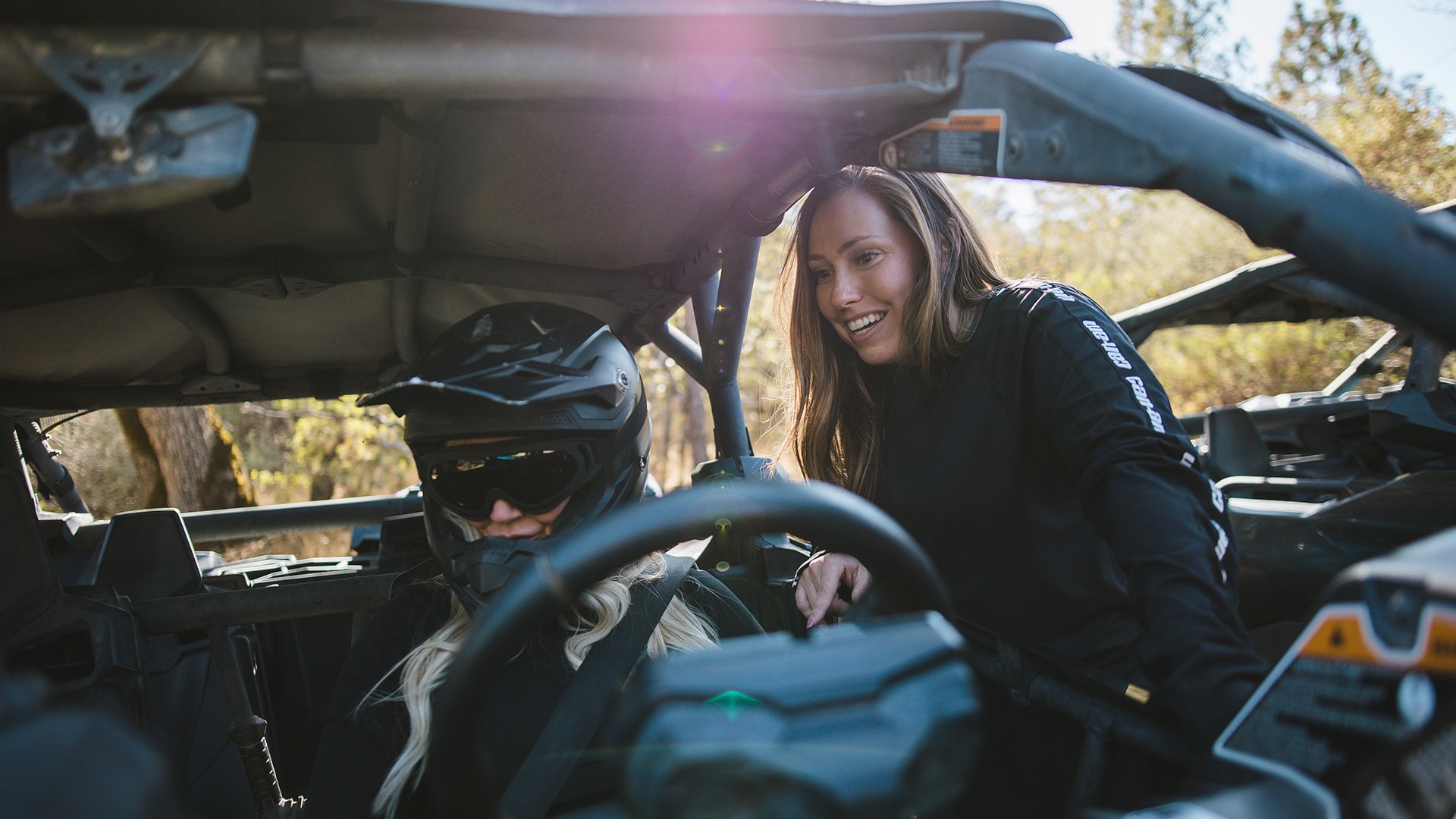Woman rider talking to a friend before heading off in her Can-Am Off-Road SxS 