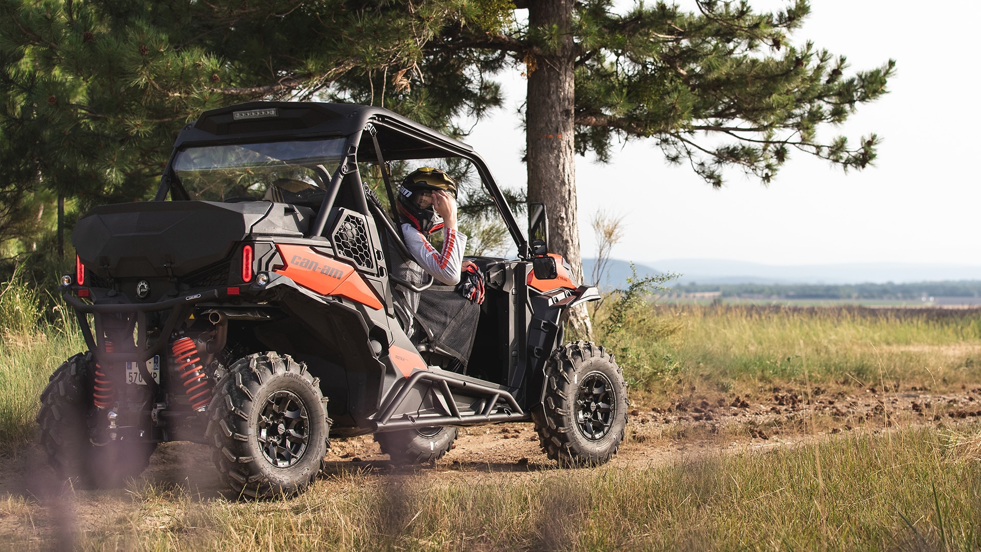 Riders taking a break from their adventure in a Can-Am Maverick Trail side-by-side vehicle