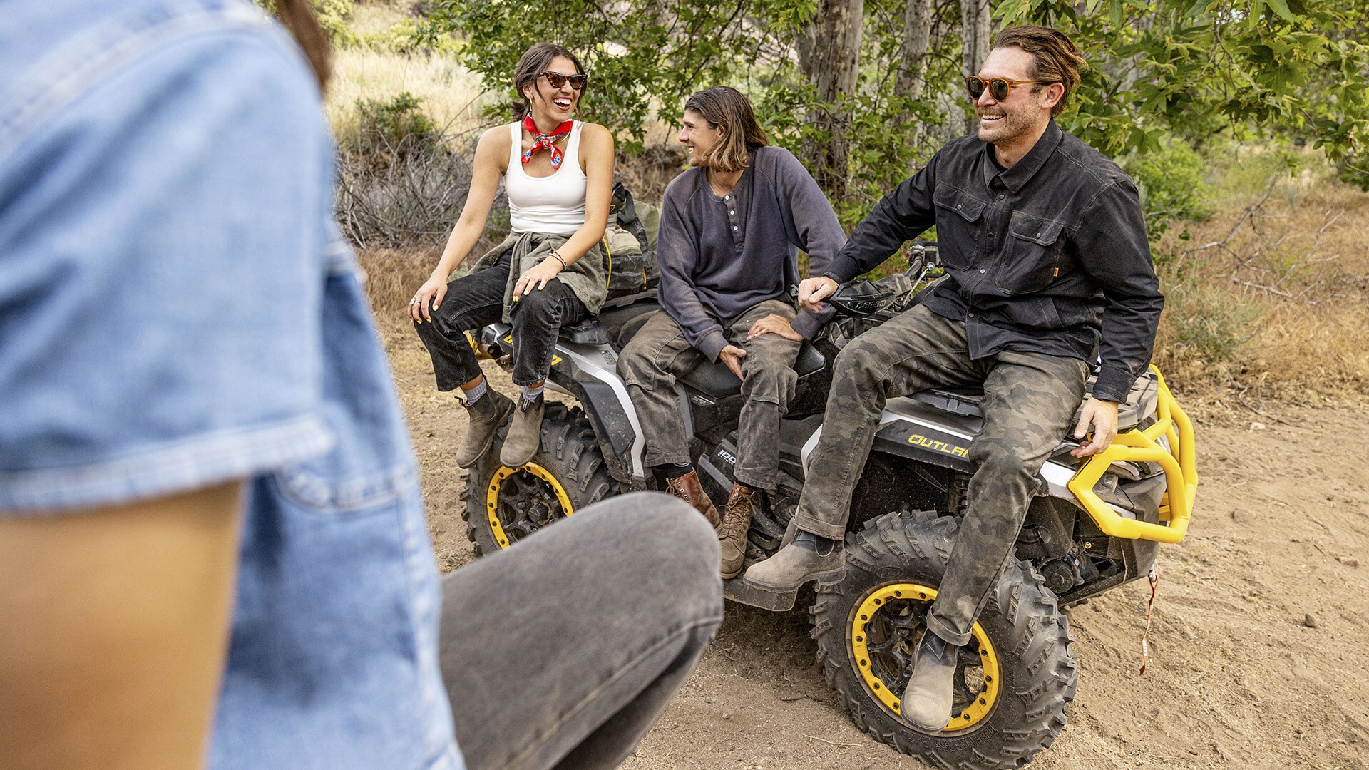 Three riders sitting on a Can-Am Outlander ATV