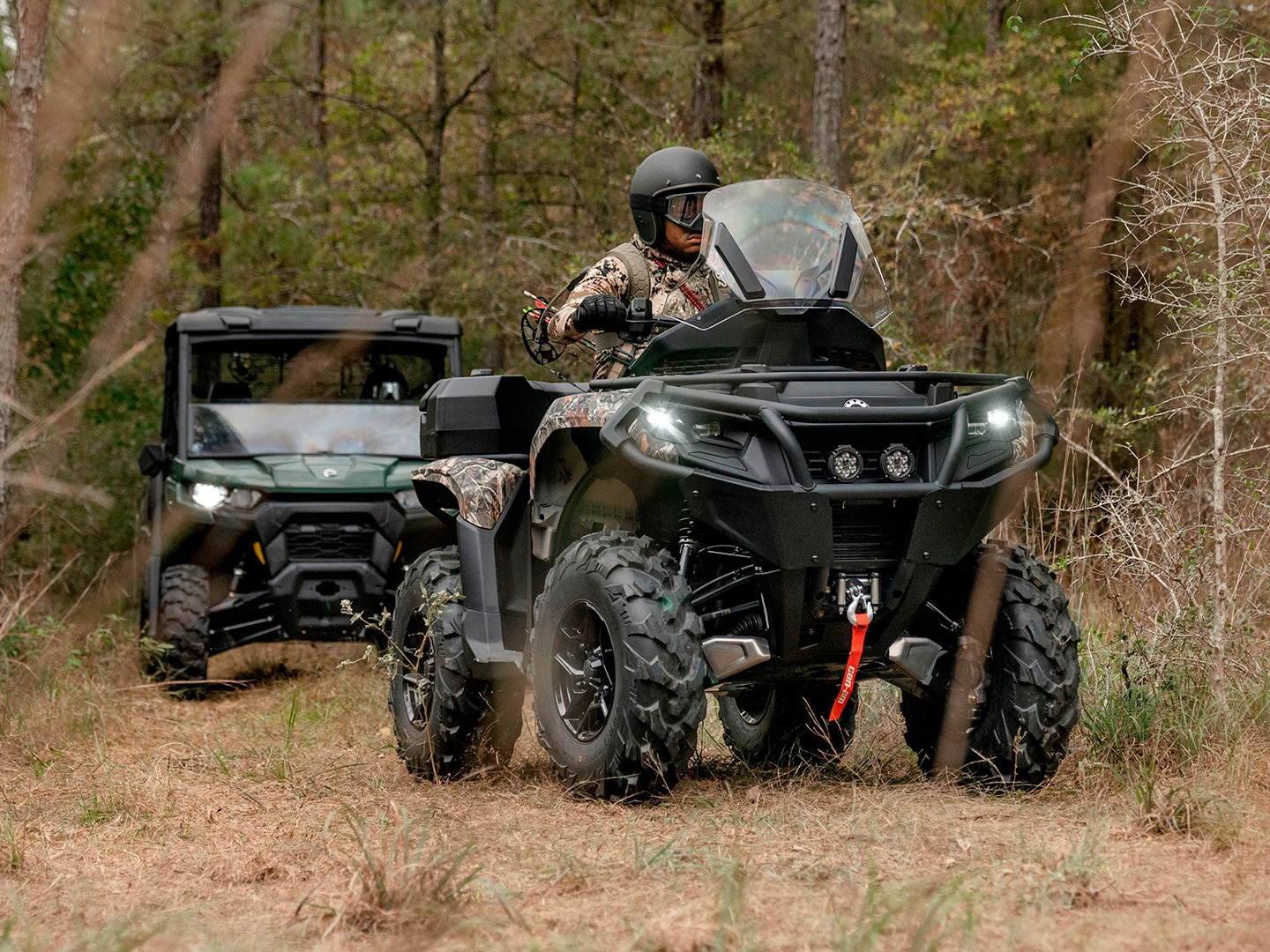 Can-Am Outlander ATV followed by a Defender side-by-side vehicle
