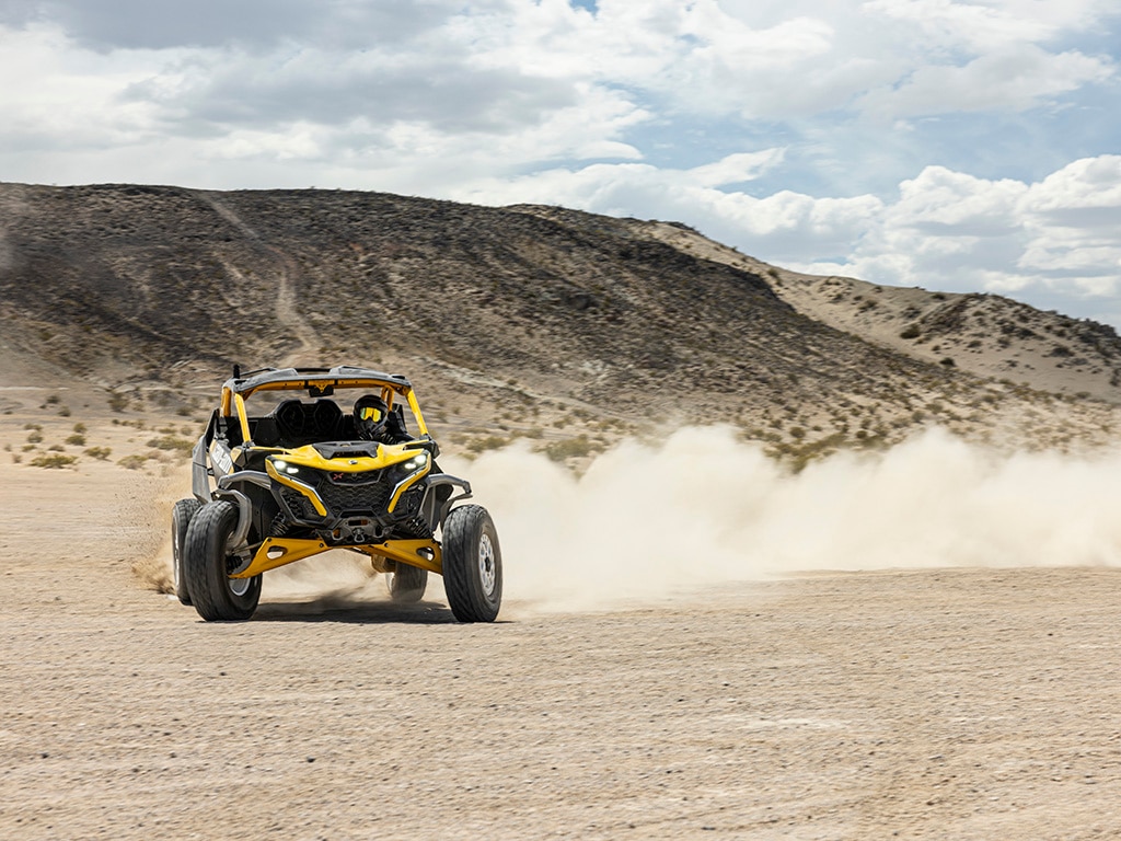 Een rijder rijdt met een Can-Am Maverick R SxS-voertuig uit de 2024 in de woestijn