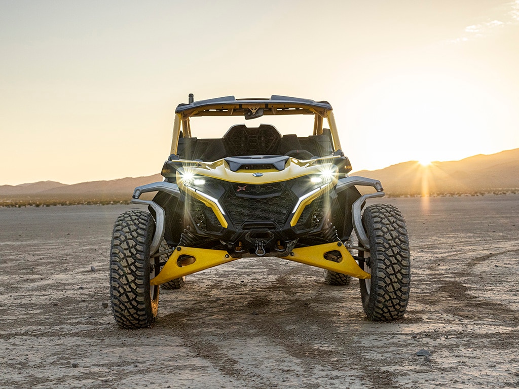 Een Can-Am Maverick R SxS geparkeerd met de lichten aan in de woestijn