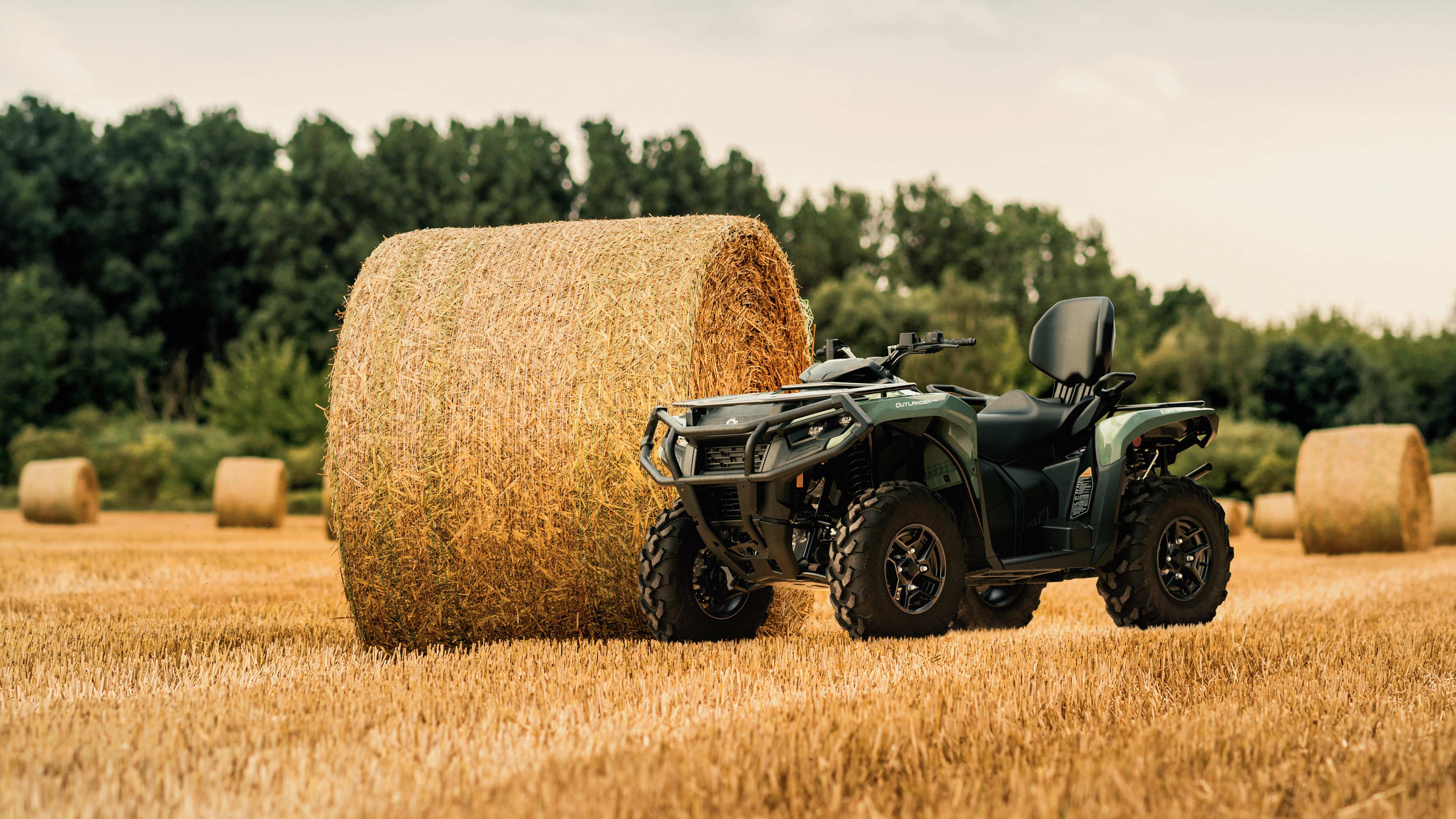 En Can-Am ATV som är konstruerad för jordbruk och står intill en höbal