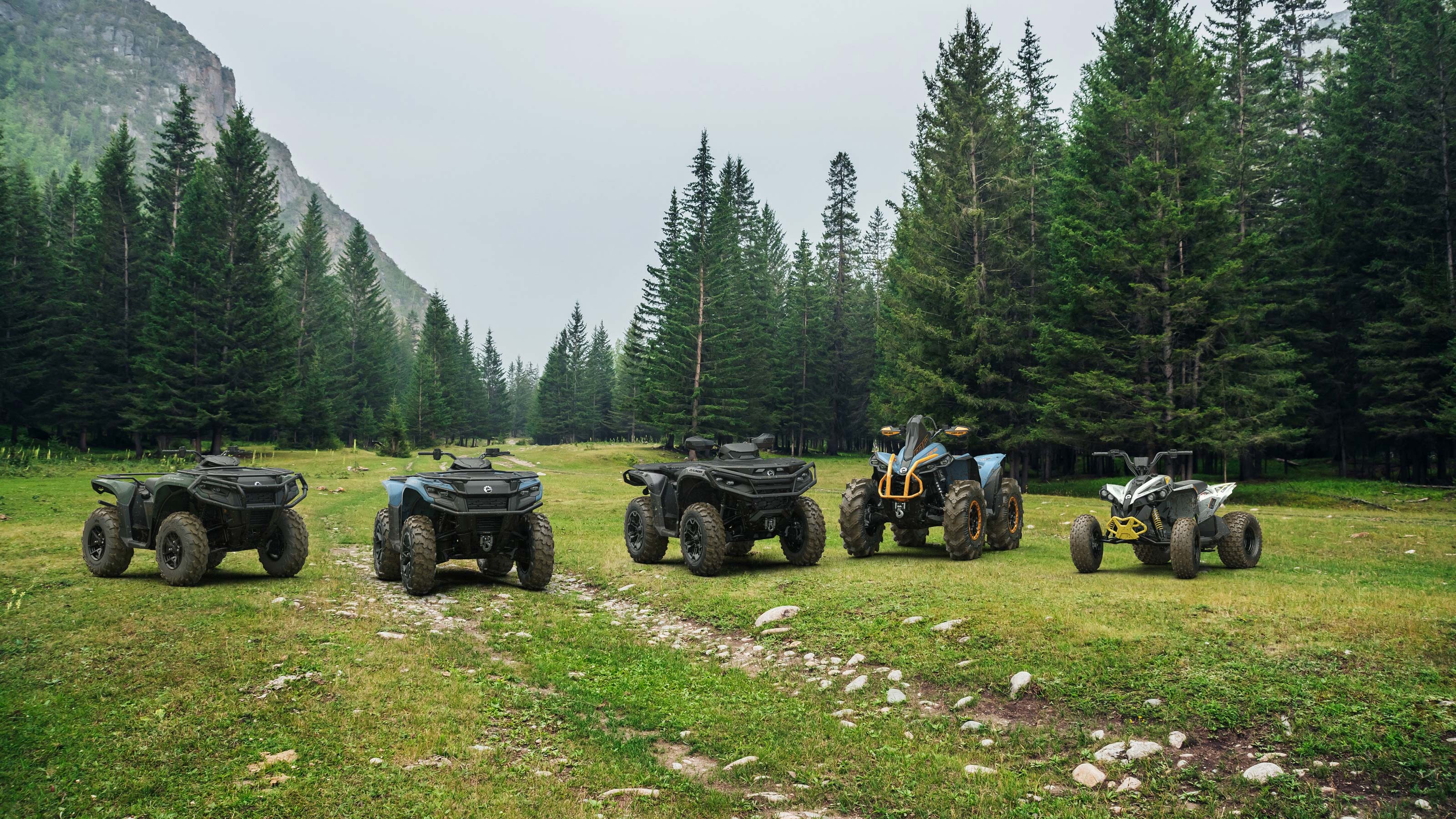 Three Outlander 500/700 ATVs following one another on a muddy trail