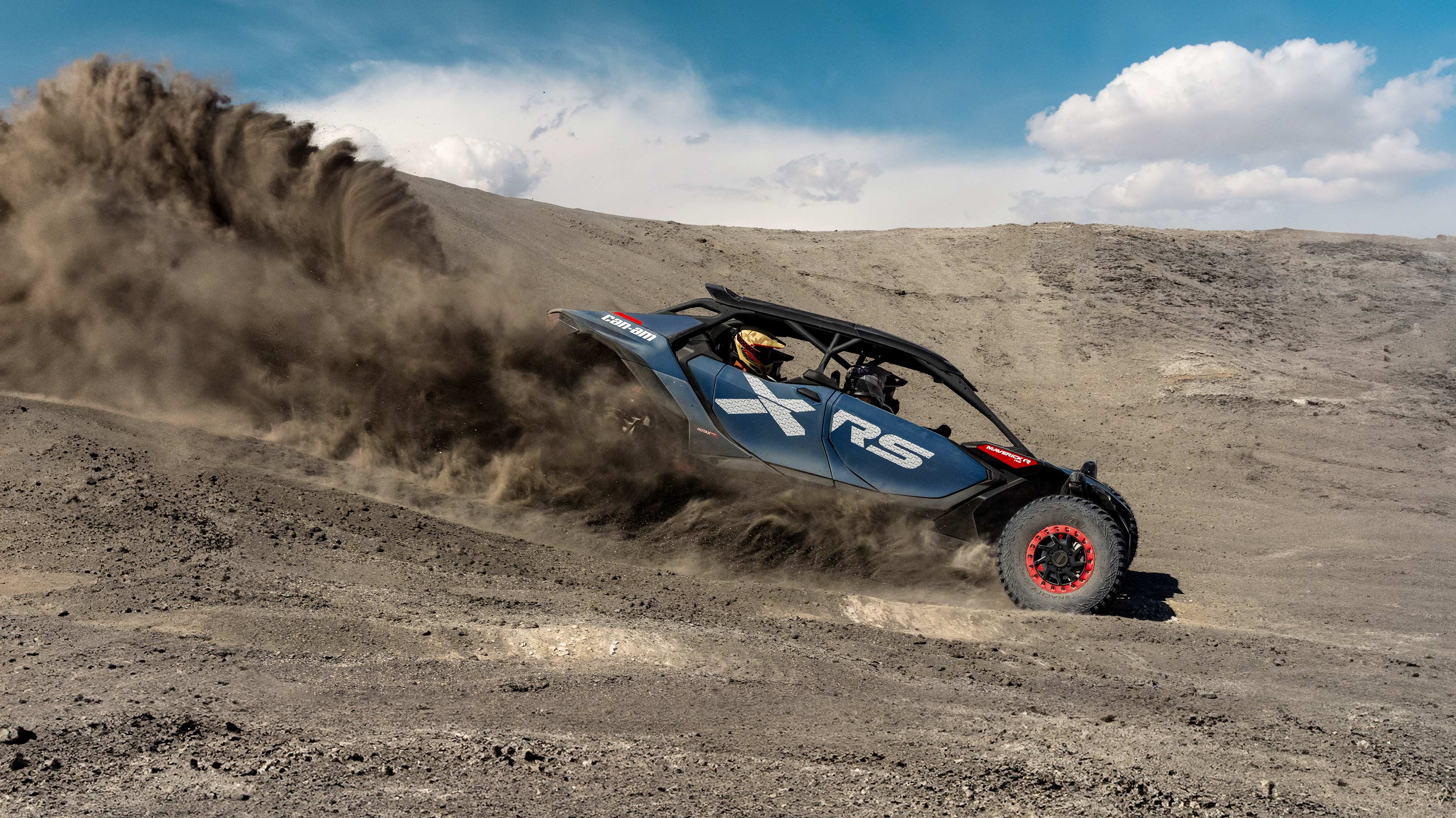 Un Can-Am Maverick R X RS 2025 dévalant un sentier poussiéreux