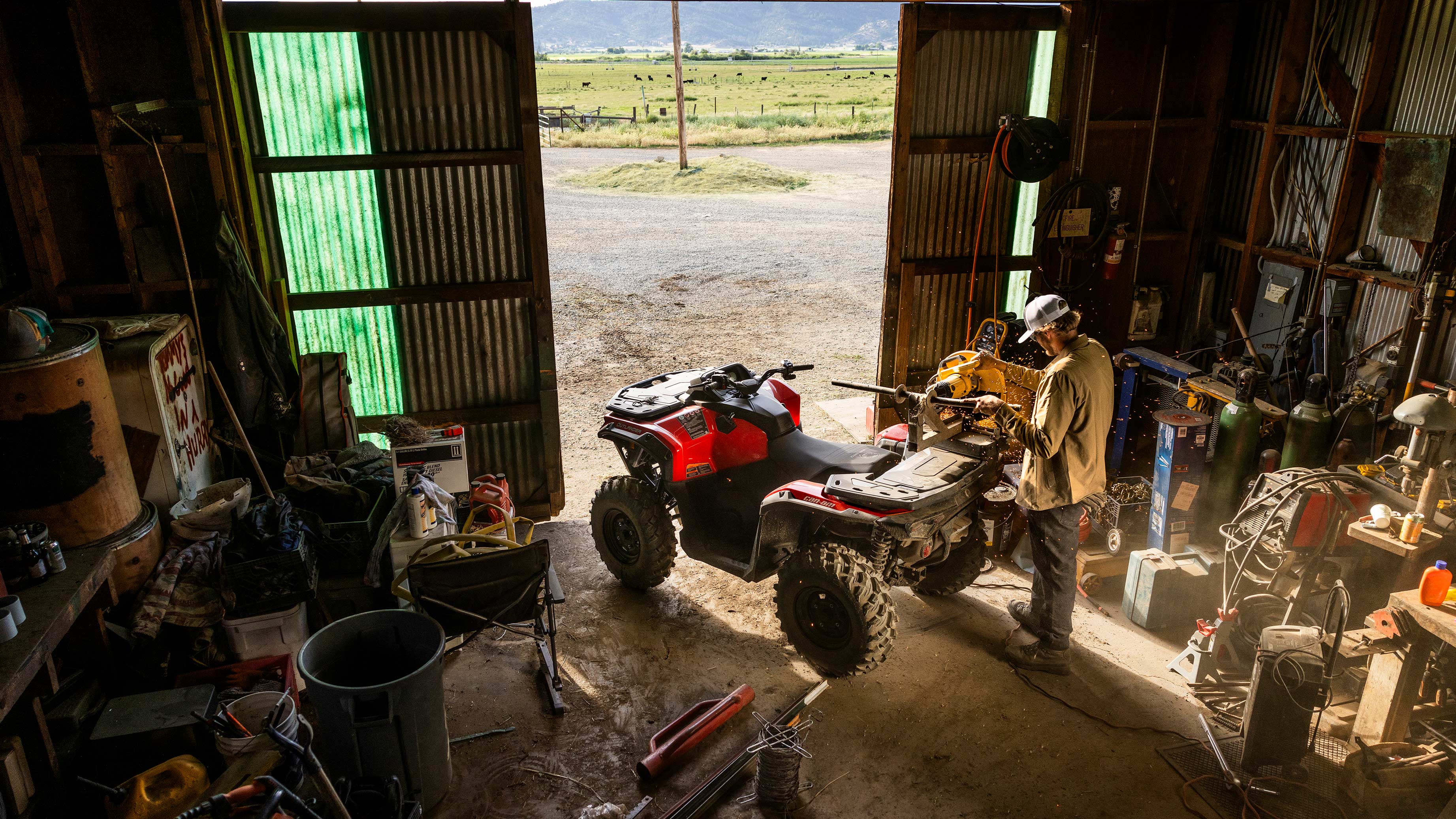 Een man onderhoudt zijn Can-Am Outlander 2025 quad in een garage