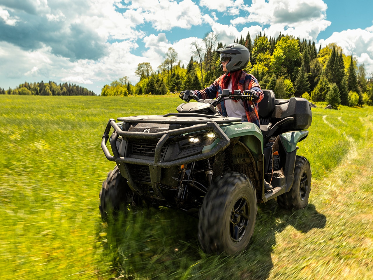 A Can-Am Outlander PRO staionned near a haystack