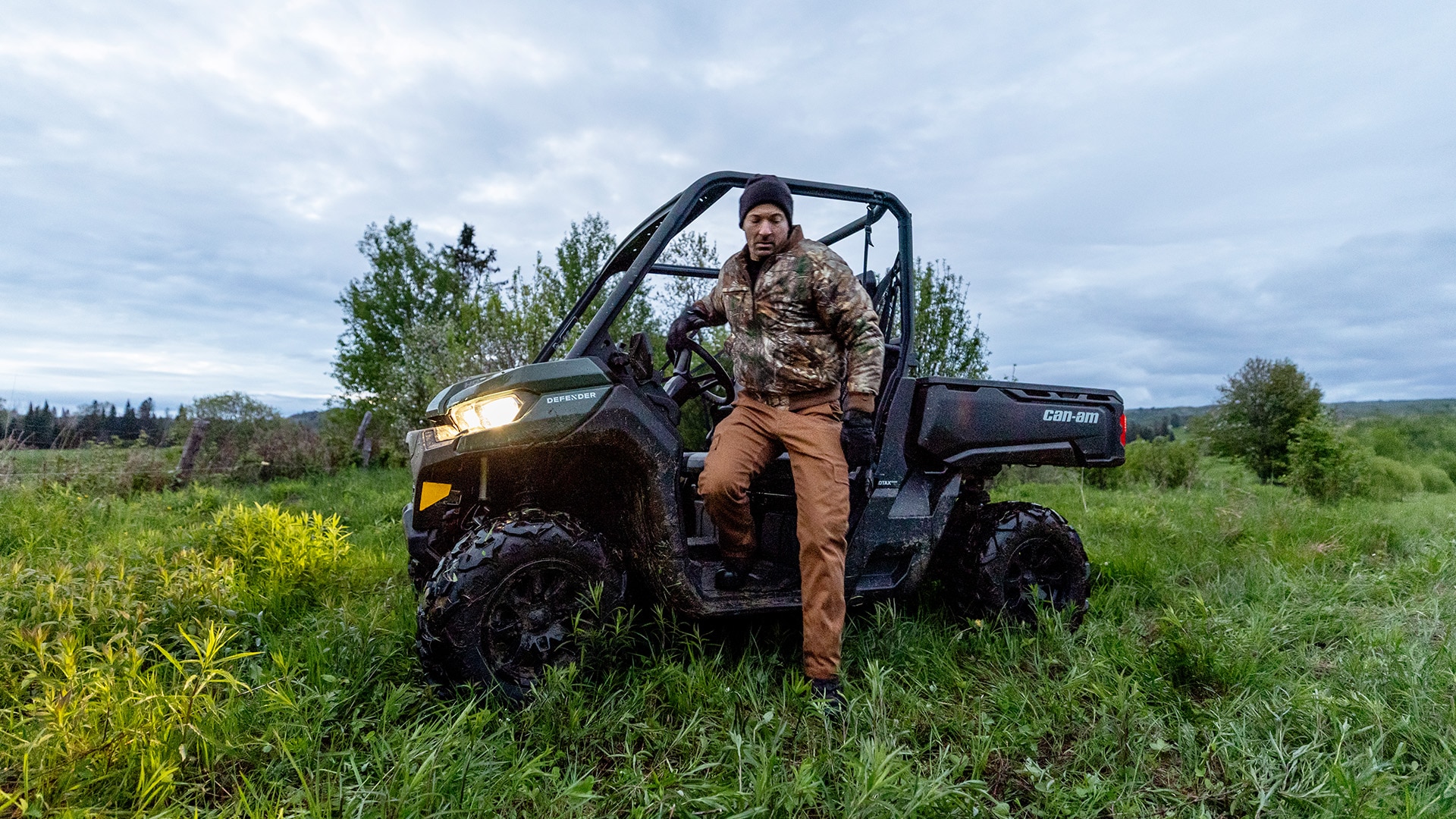 A hunter getting out of his 2026 Can-Am Defender DPS HD7 side-by-side