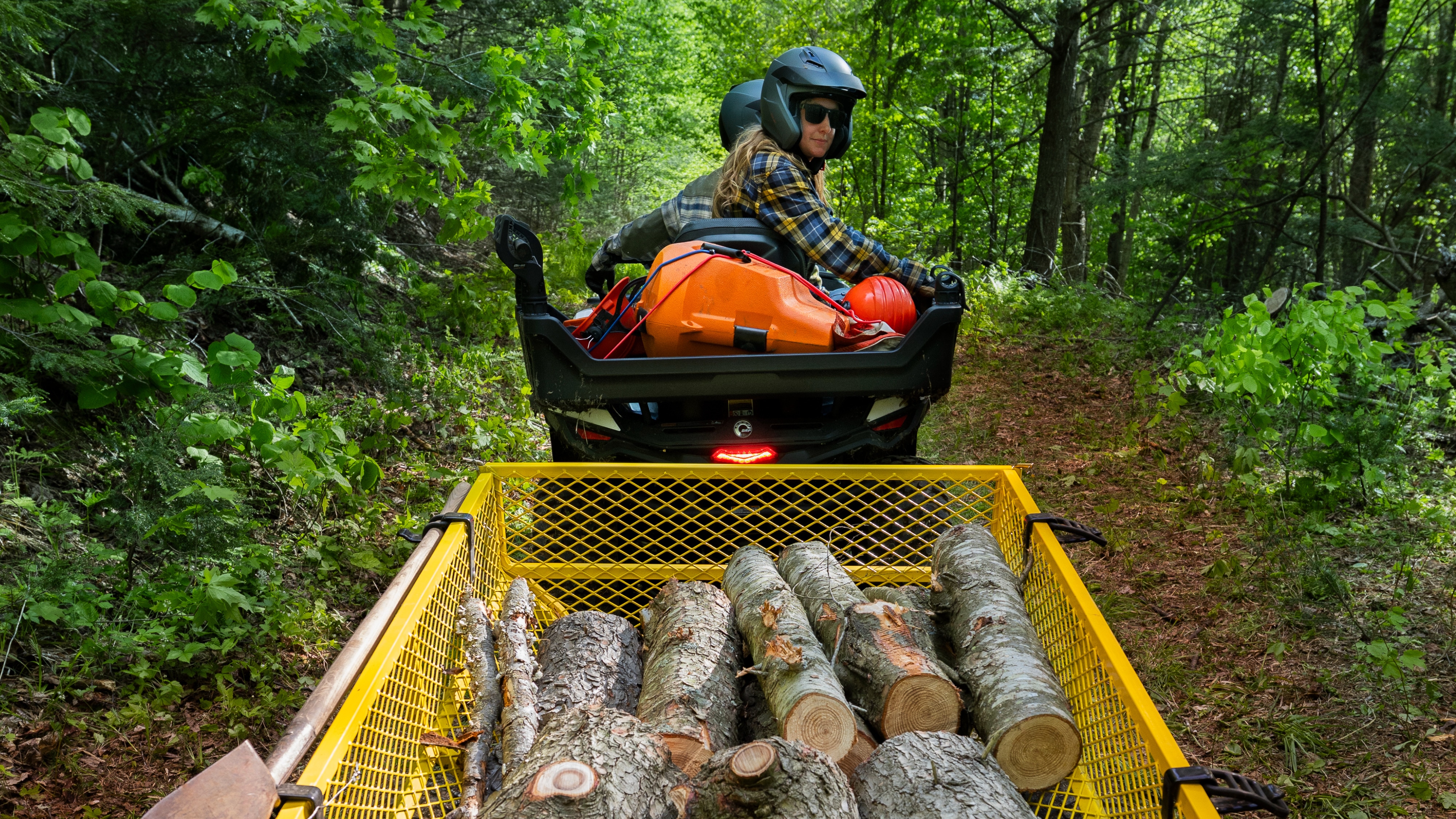 Un couple transportant des bûches avec leur quad électrique Can-Am Outlander