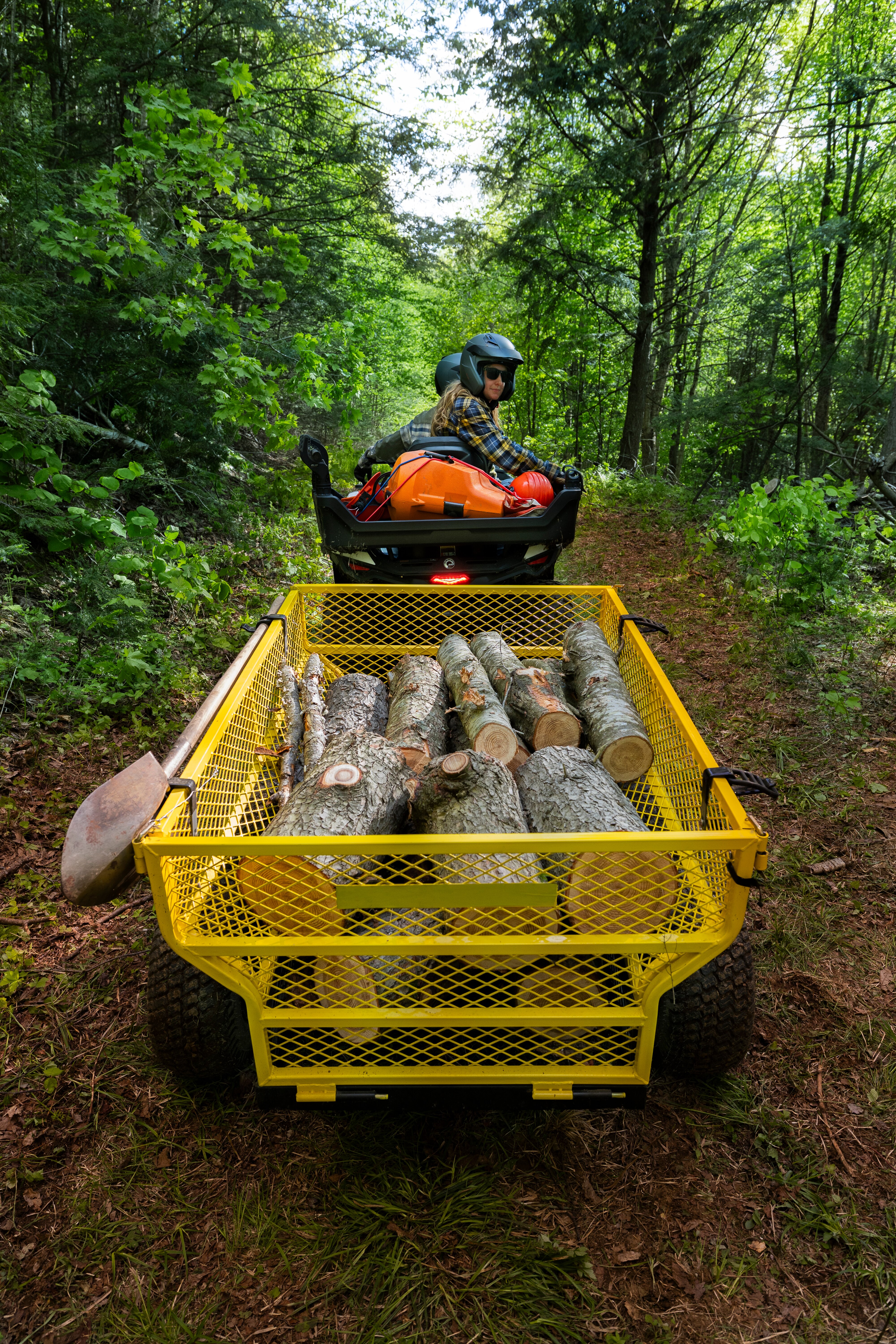 Ett par som transporterar stockar med sin elektriska Can-Am Outlander ATV