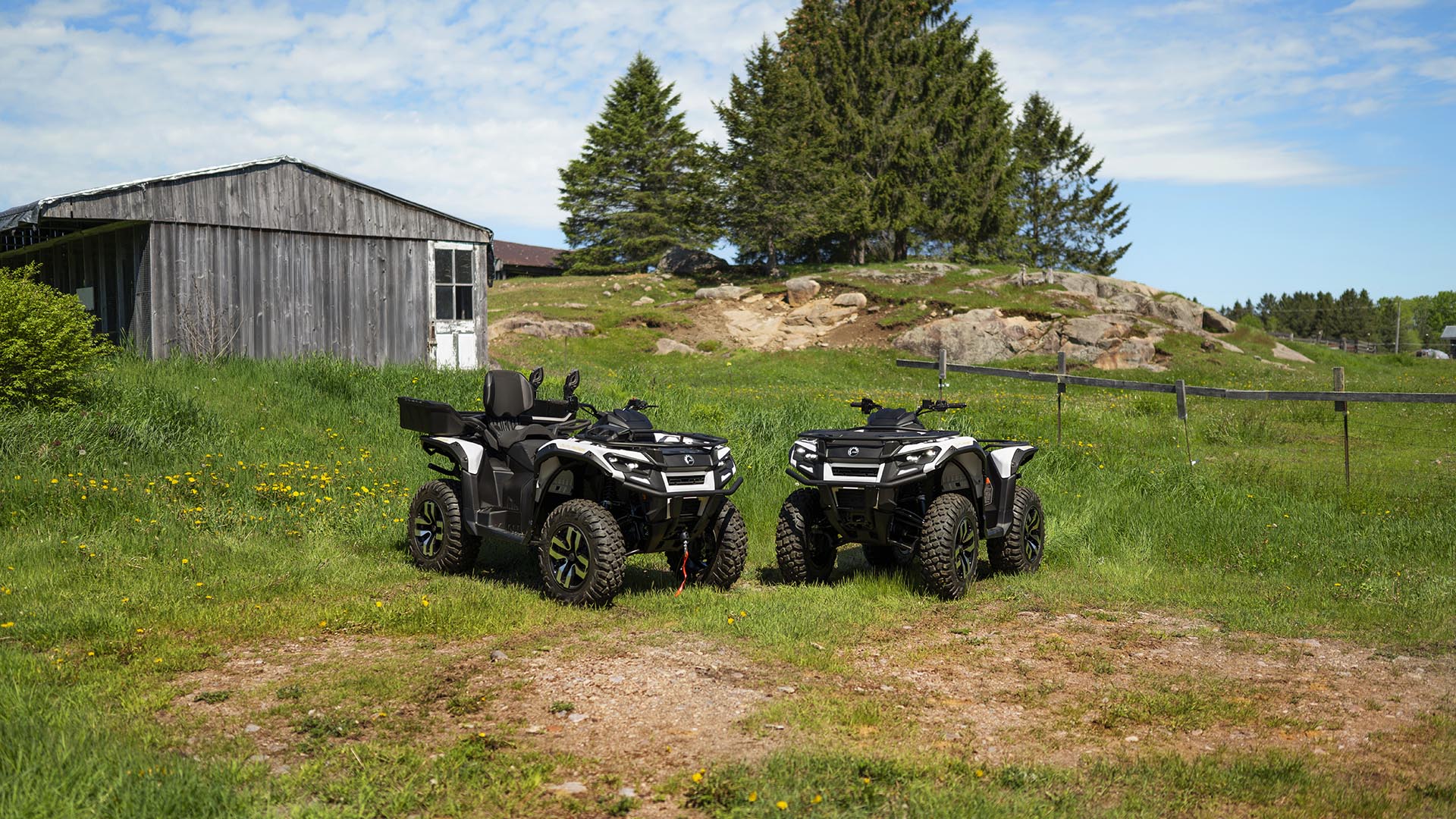 Twee Can-Am Outlander elektrische ATV’s geparkeerd in het gras