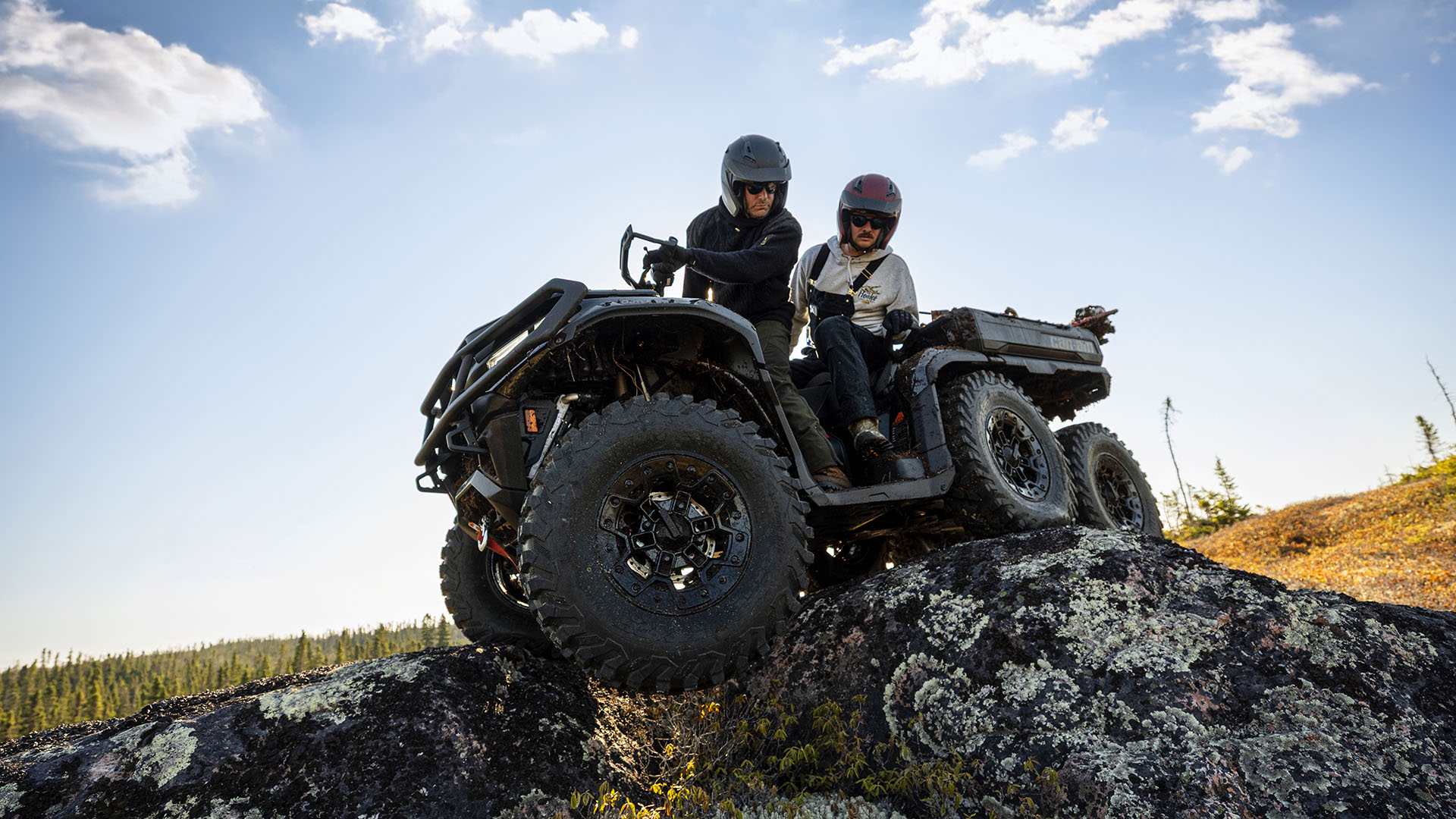 Twee bestuurders rijden over een rots in hun 2026 Can-Am Outlander Max 6x6