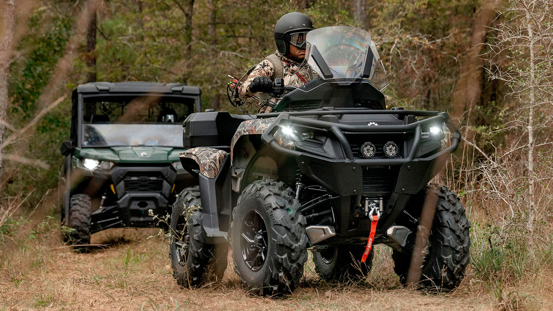 A Can-Am side-by-side and ATV following each other through the forest, ready to go hunting