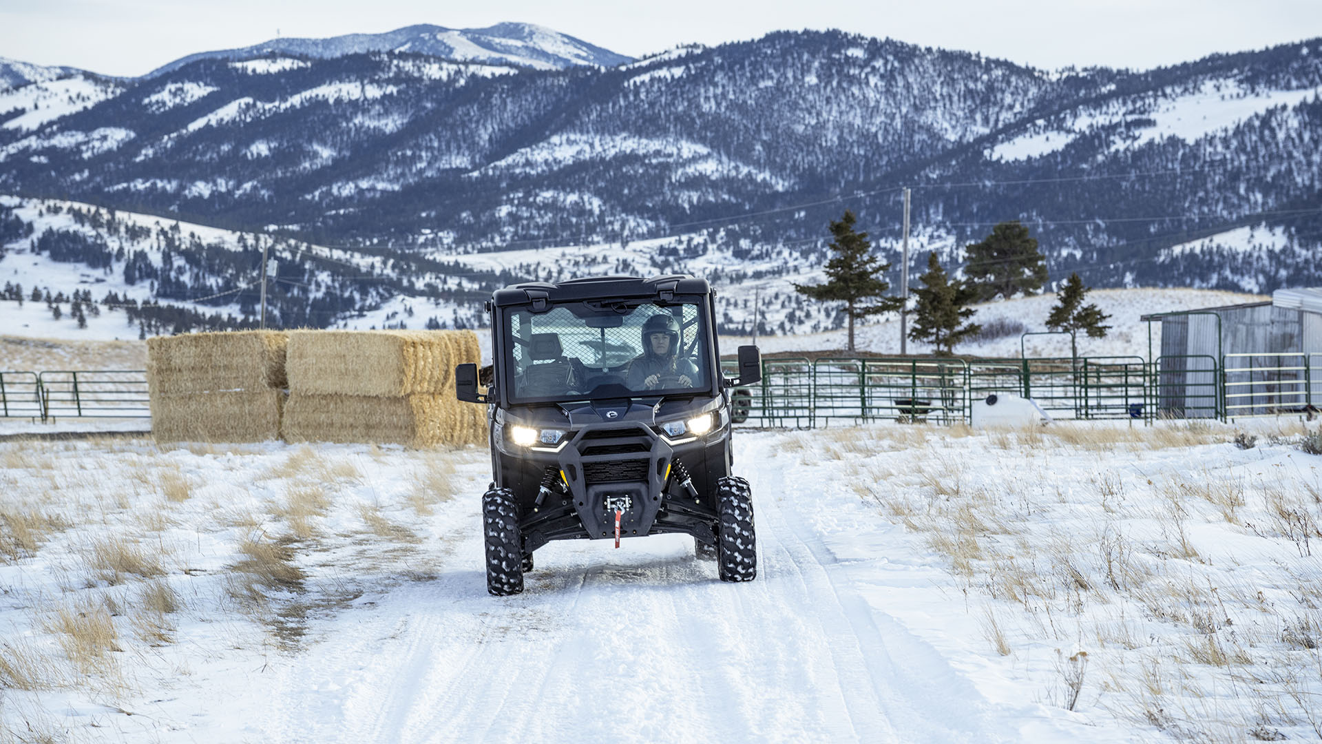 Vehículo Can-Am Defender SxS conduciendo en un campo nevado