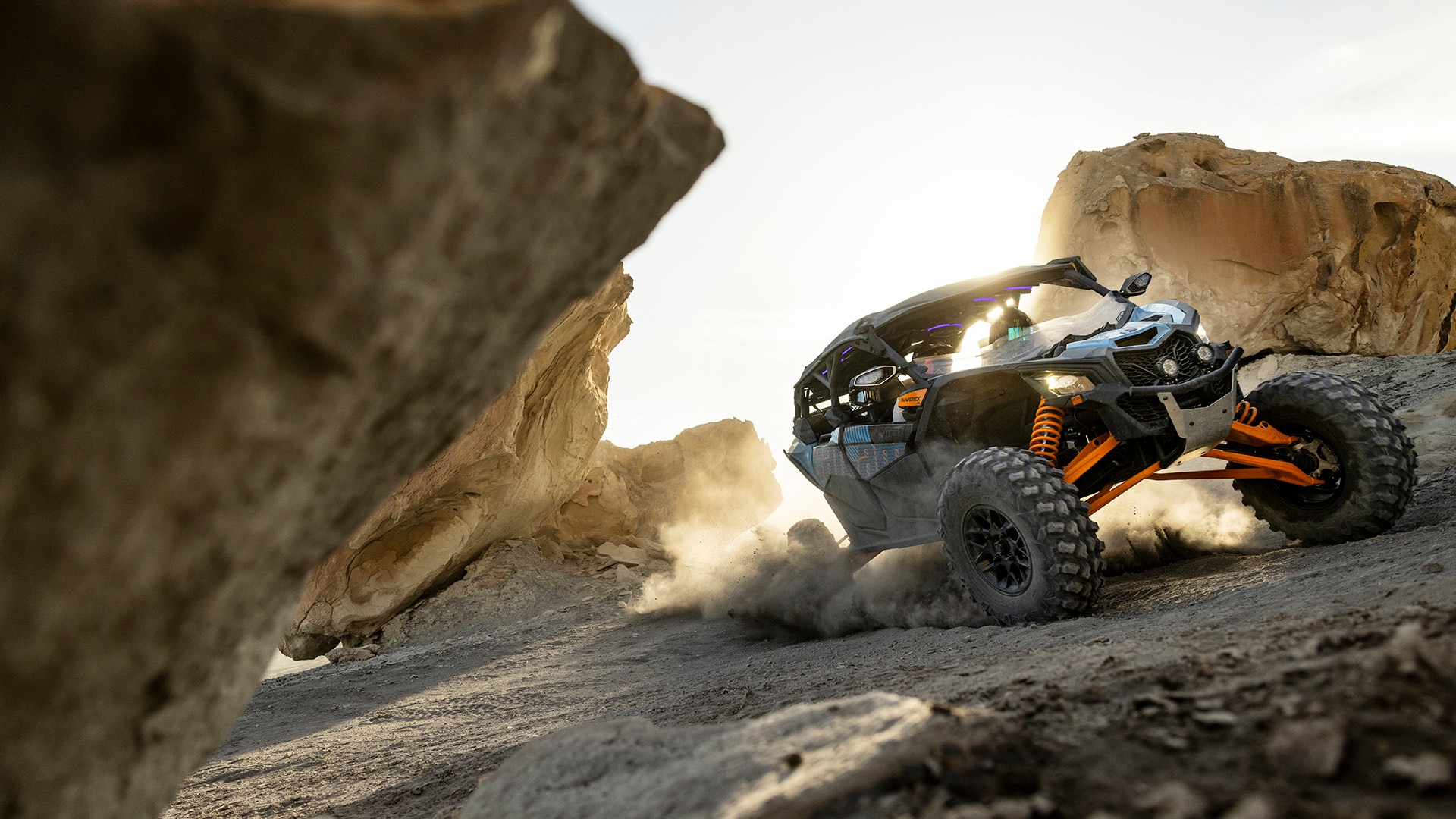 A Can-Am Maverick X3 MAX RS Turbo, rolling between rocks in the sand