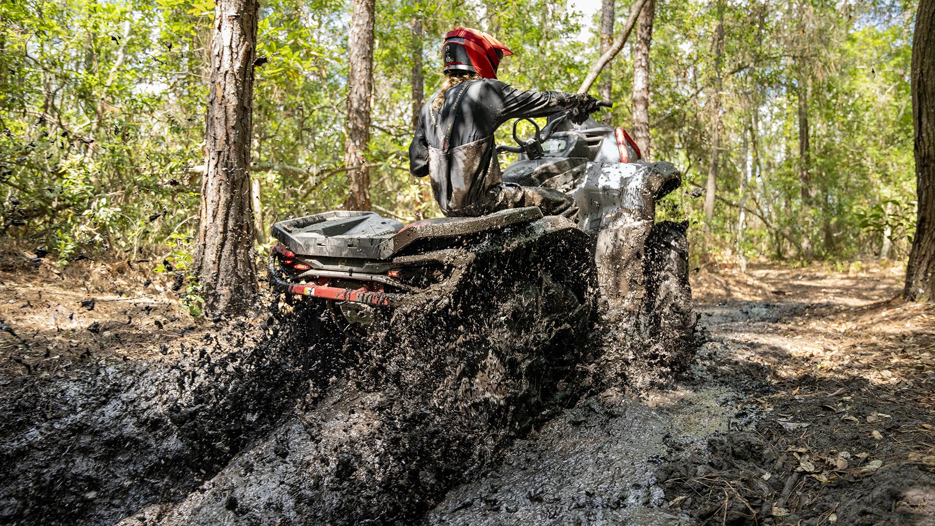 A rider on a Can-Am Outlander X mr 1000R ATV in the mud