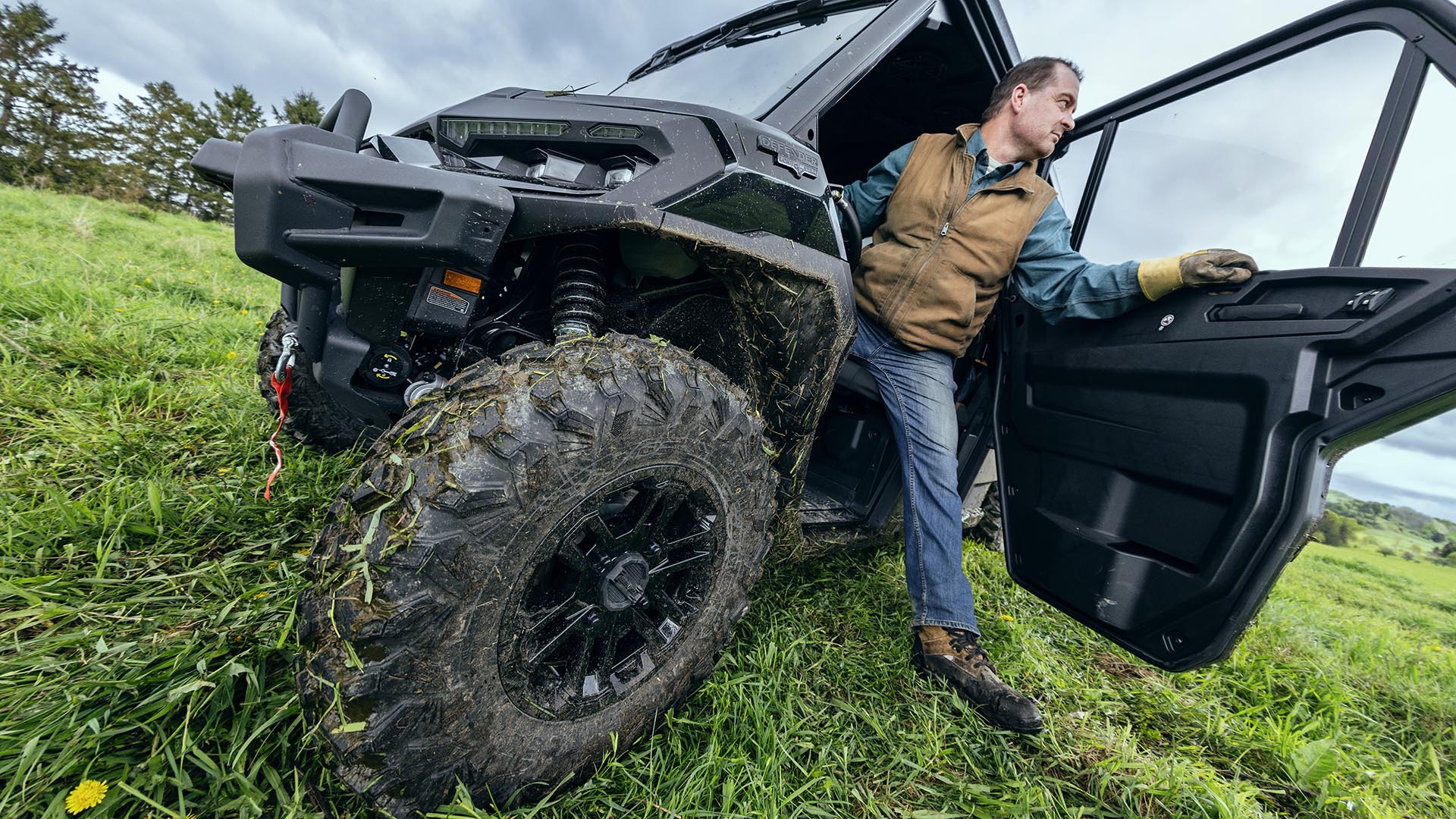 A farmer stepping out of his 2026 Can-Am Defender MAX Lonestart side-by-side vehicle on his land