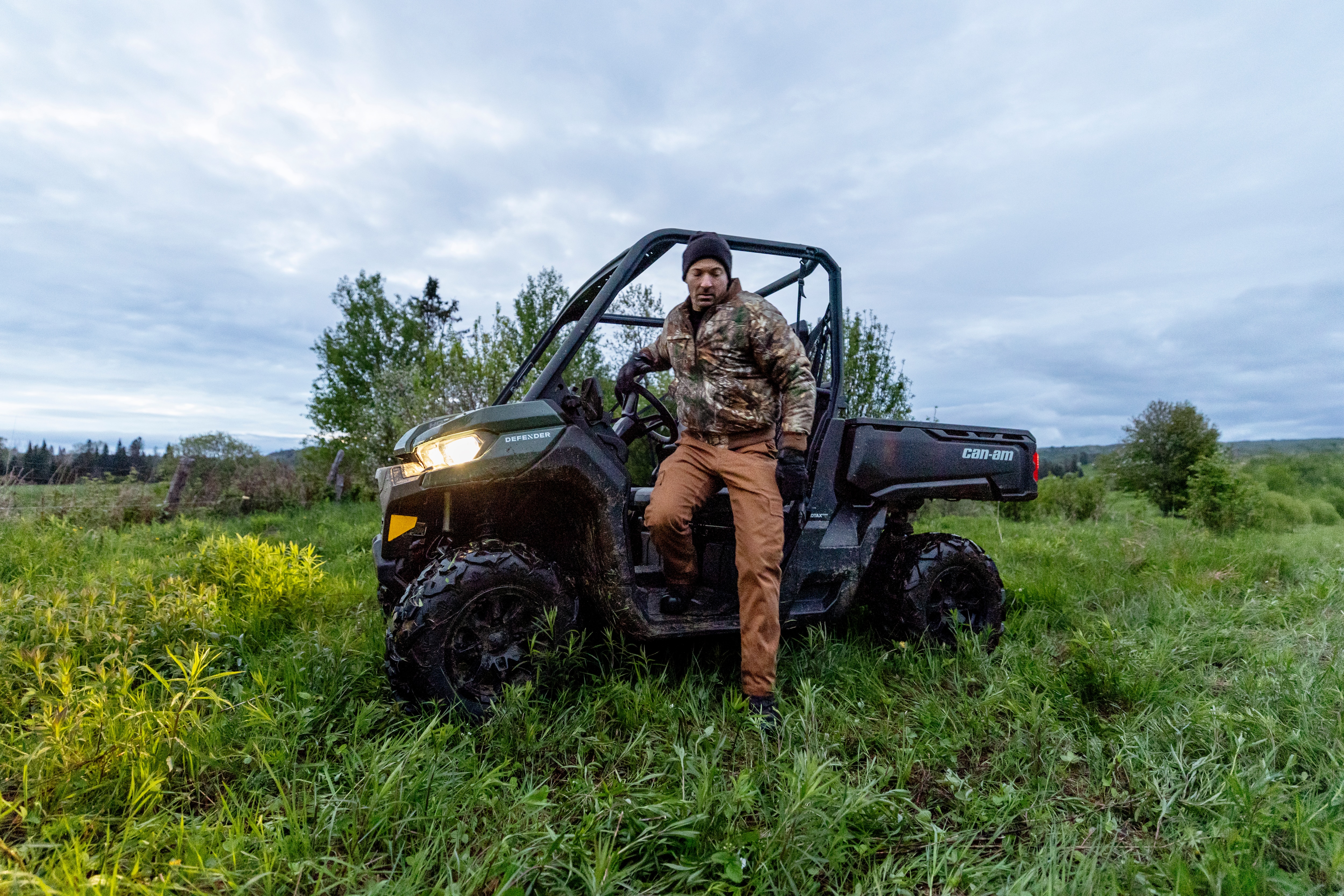 A hunter getting out of his 2026 Can-Am Defender DPS HD7 side-by-side