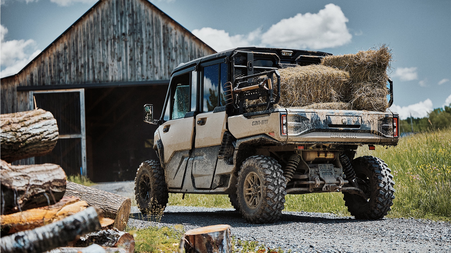 Un véhicule côte à côte Can-Am Defender 2027 sur un chemin de gravier d'une ferme