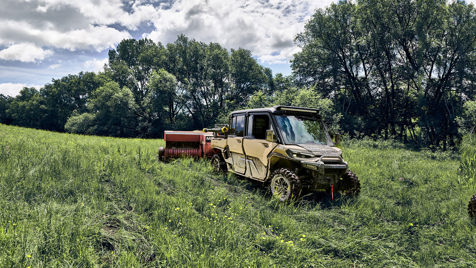 Un vehículo side-by-side Can-Am Defender totalmente equipado aparcado en la hierba de una granja