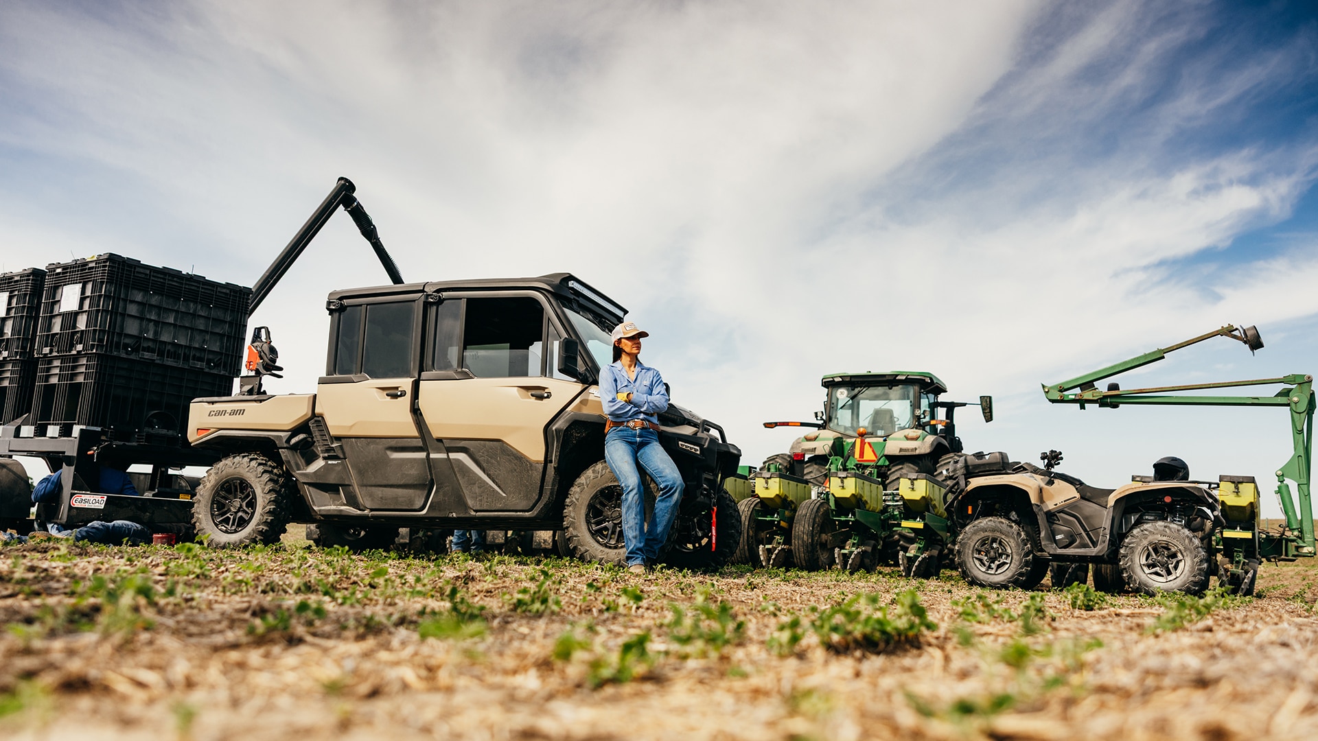 A woman sitting next to her Can-Am Defender XU HD10/HD11, near other utility vehicles
