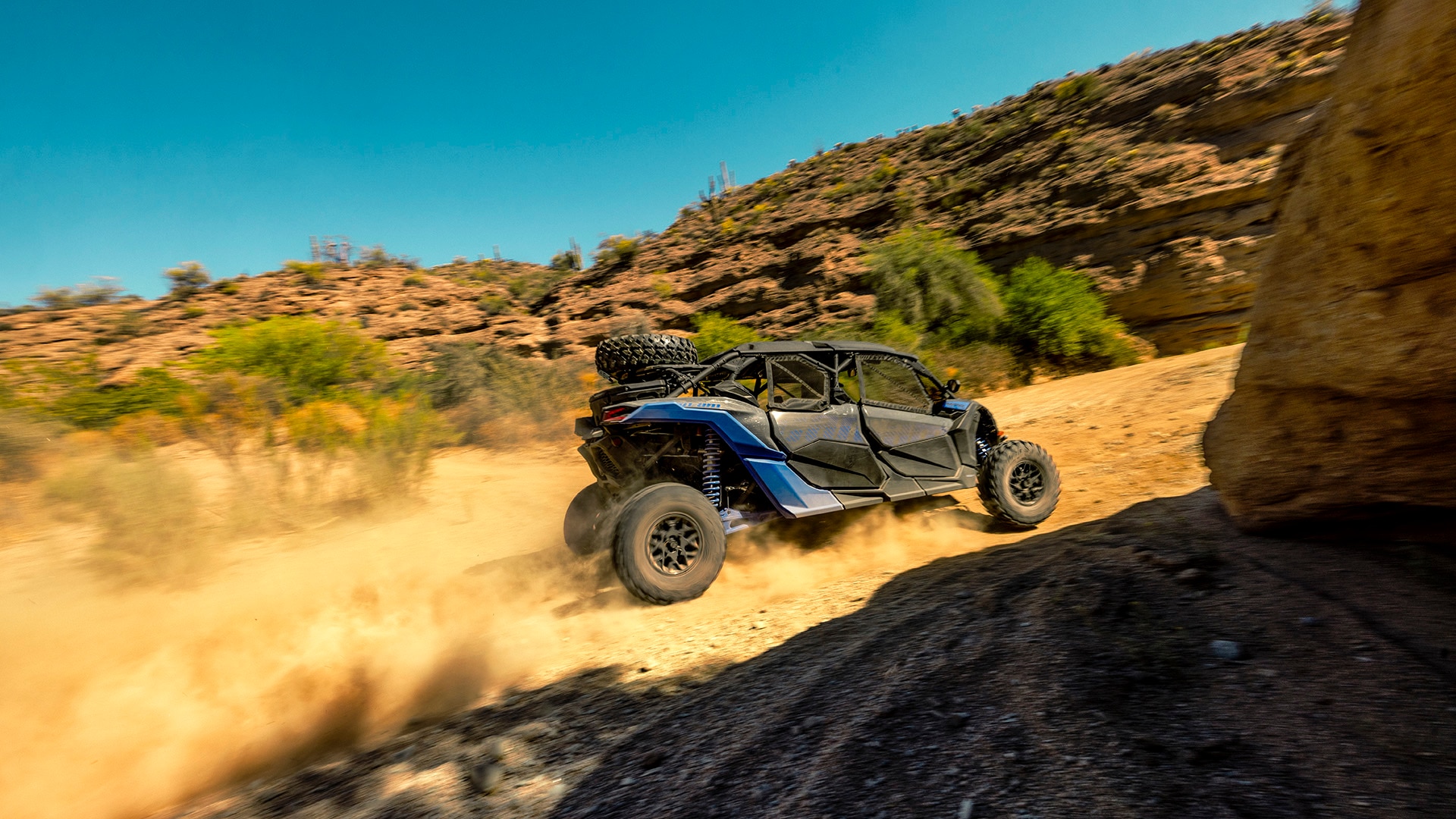 Un vehículo side-by-side Can-Am Maverick X3 2027 subiendo una pendiente rocosa en el desierto