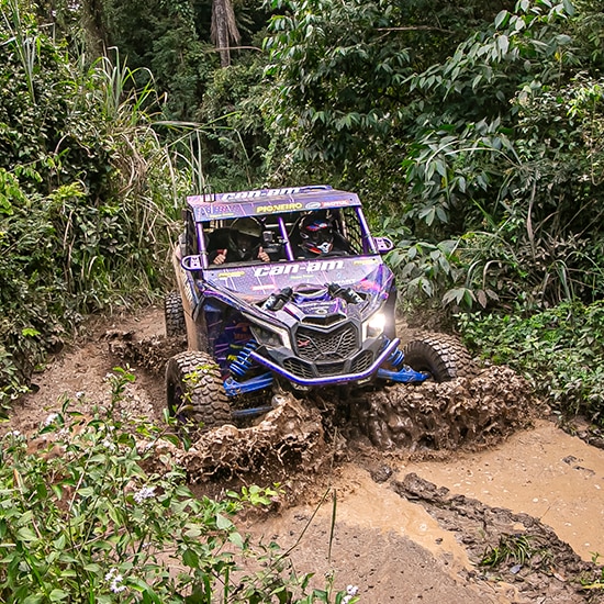 Veículo Can-Am manobrando pela lama.