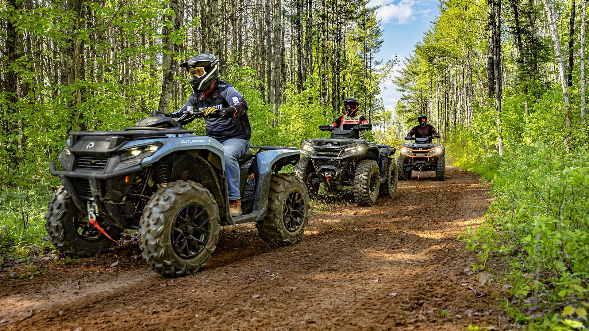 Un grupo conduciendo tres Can-Am Outlander 2026 por un sendero desértico 