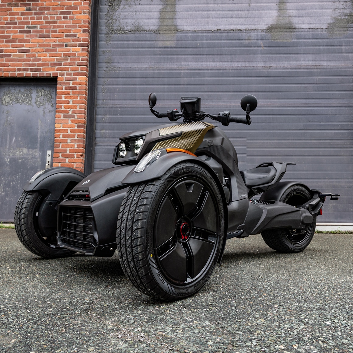 The redesigned 2027 3-wheel motorcycle Can-Am Ryker parked in front of building