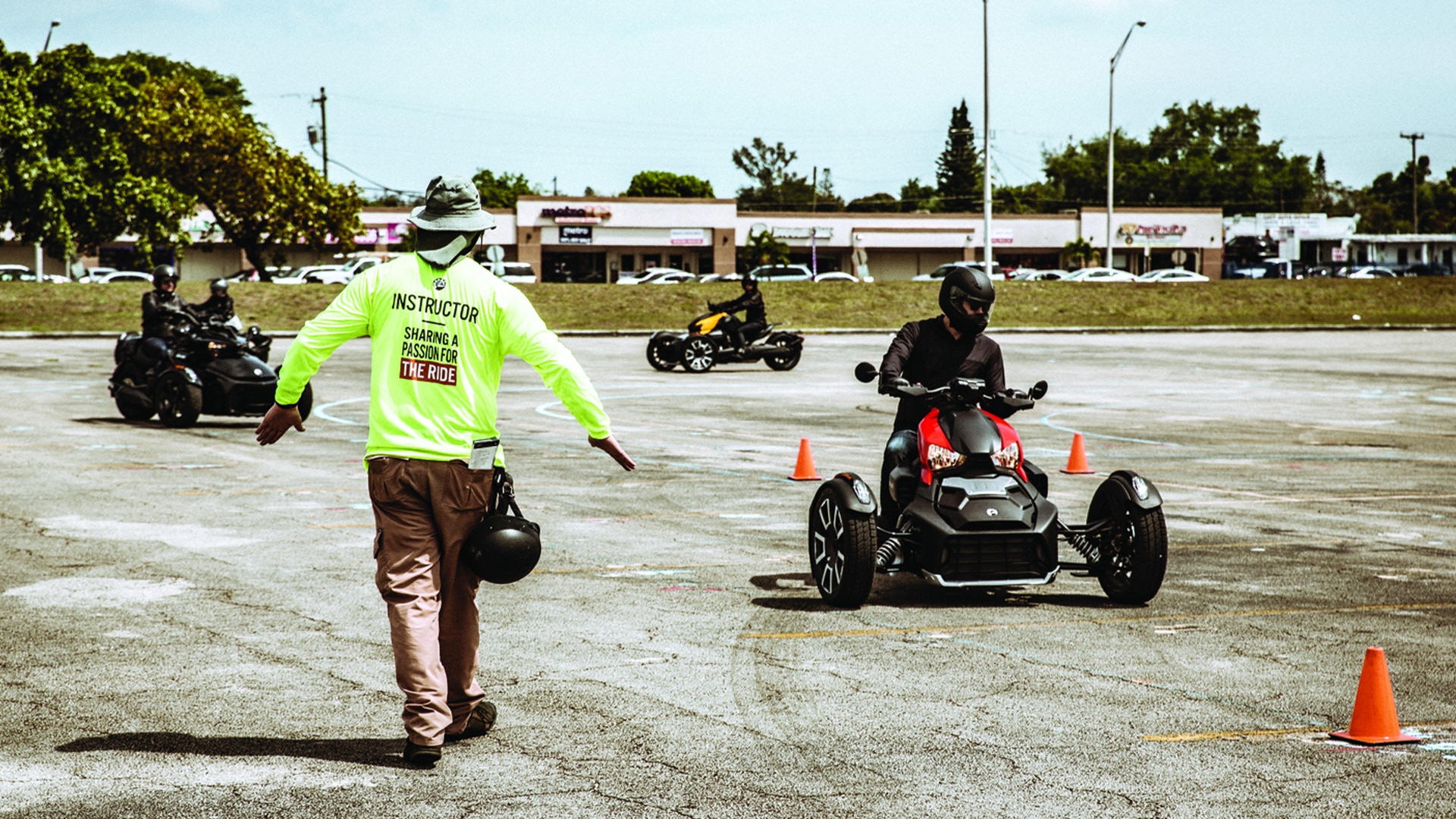 Instructor teaching driving students to drive 3-wheel Can-Am vehicles