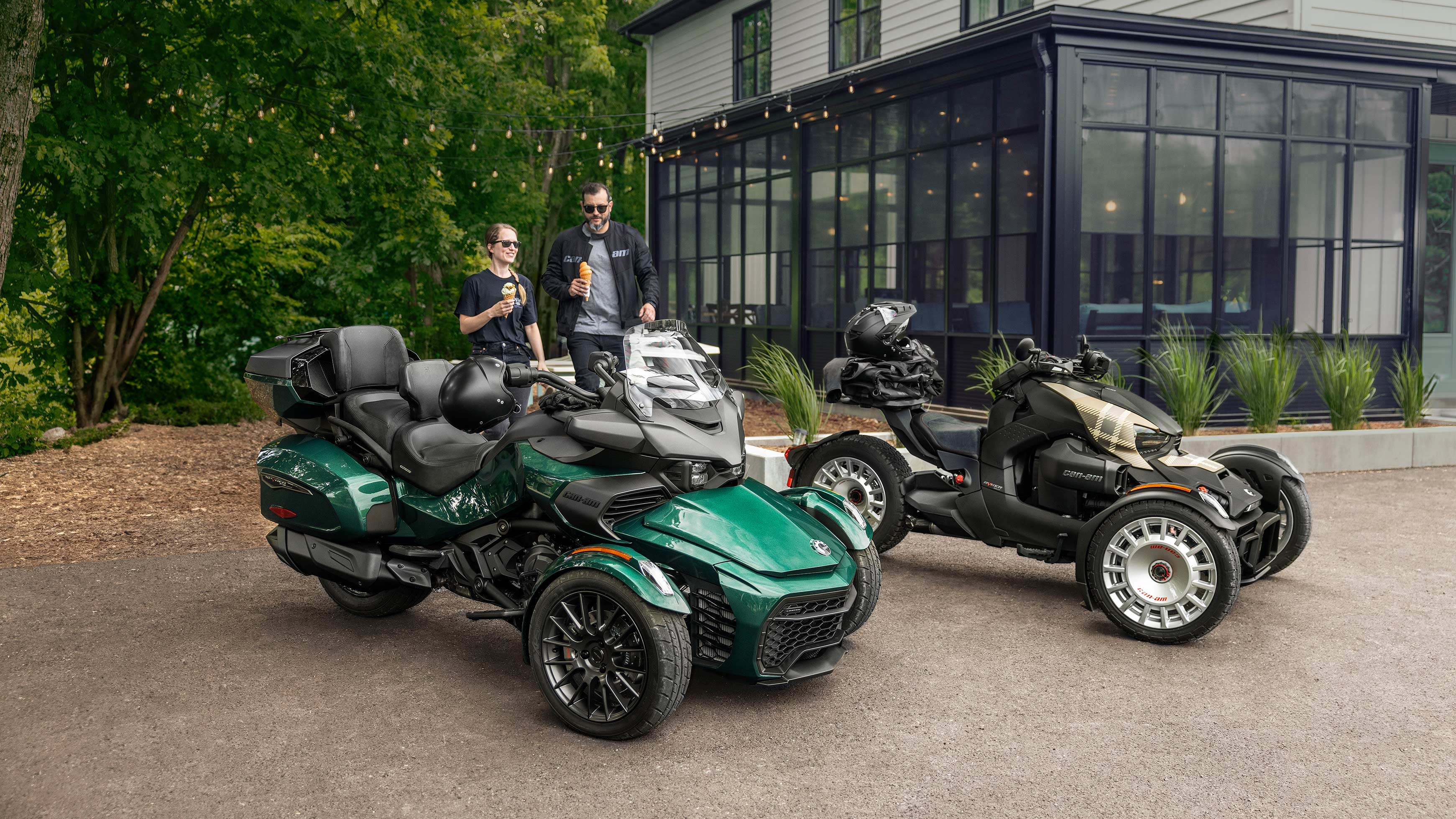 Two people eating an ice cream next to Can-Am 3-Wheel vehicles