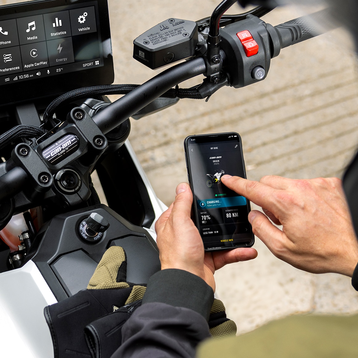 A user on their electric motorcycle checking key bike information via the BRP GO! app