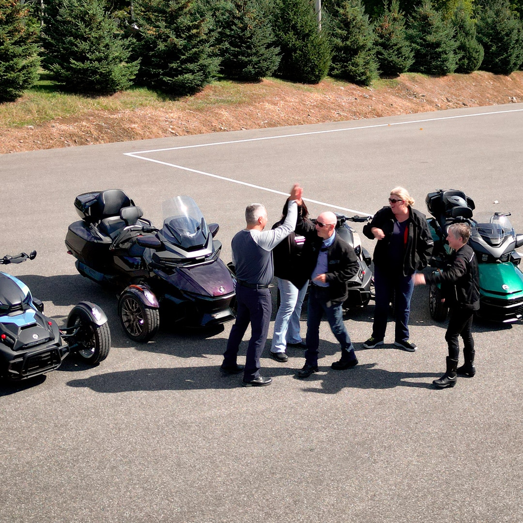 A group of people learning how to ride Can-Am 3wheel vehicles