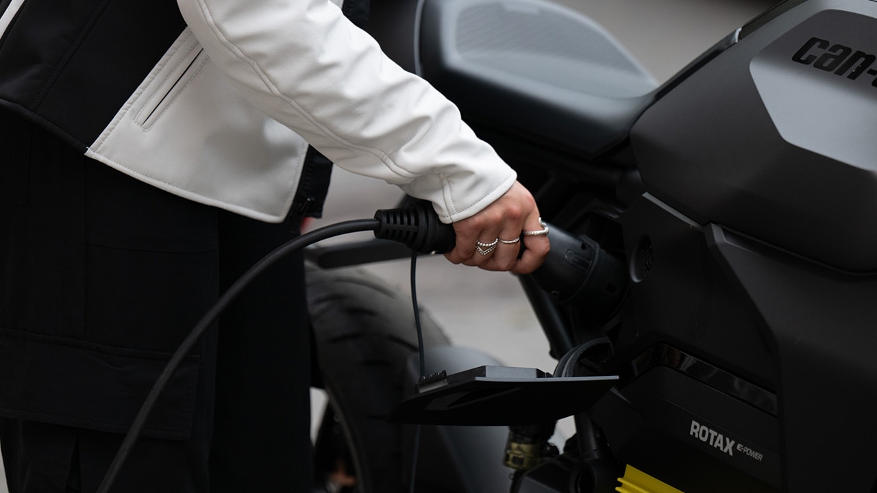 Woman charging her Can-Am electric motorcycle