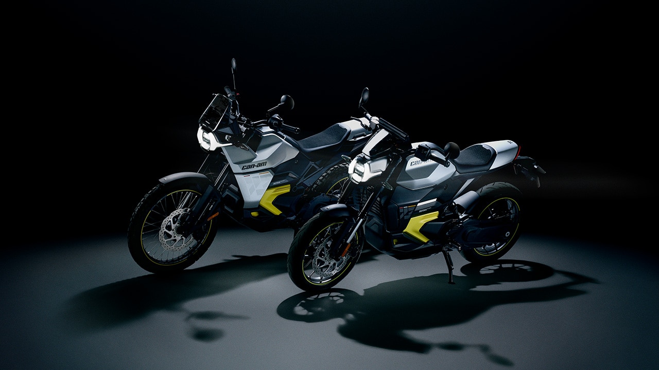 The two 2026 Can-Am electric motorcycle models lit up in a dark room