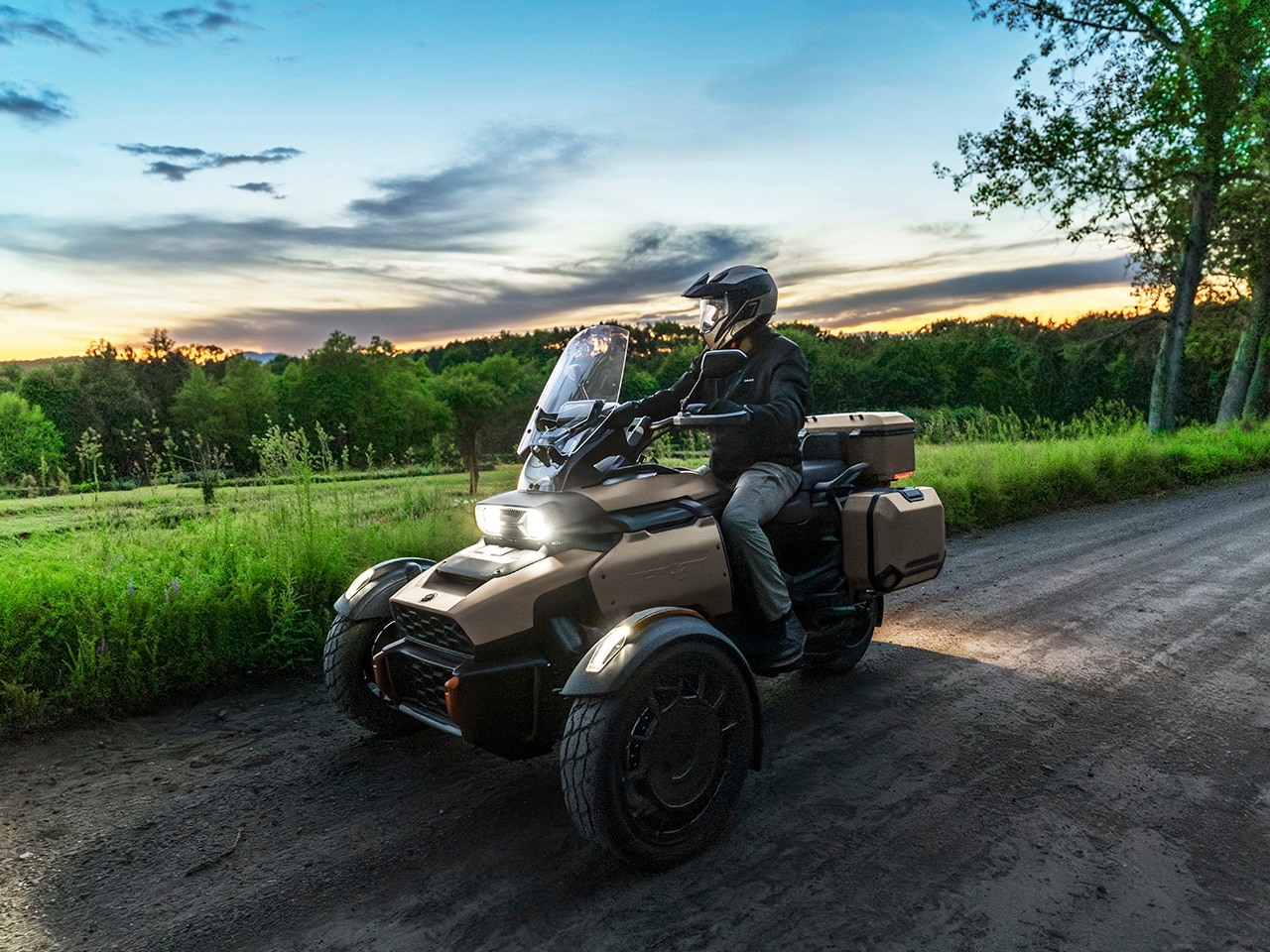 Un motocycliste assis sur un Can-Am Canyon 2027 en campagne au coucher du soleil