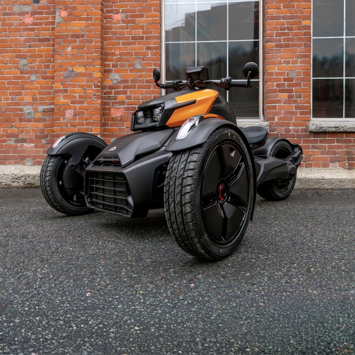 Un Can-Am Ryker 2027 stationné dans une allée devant une porte de garage