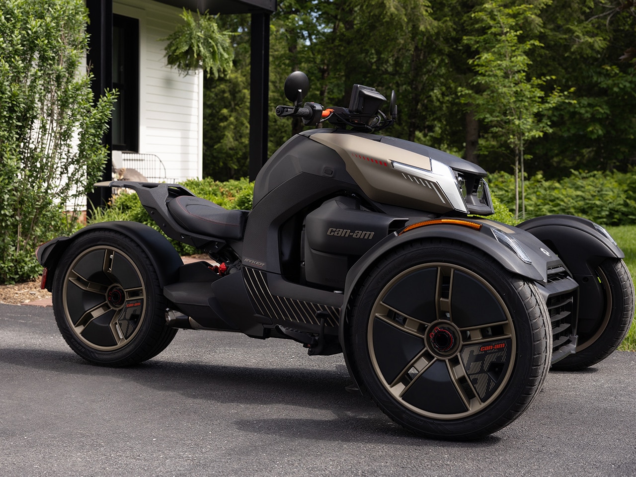 Le nouveau Can-Am Ryker 2027 stationné devant une élégante maison blanche en forêt