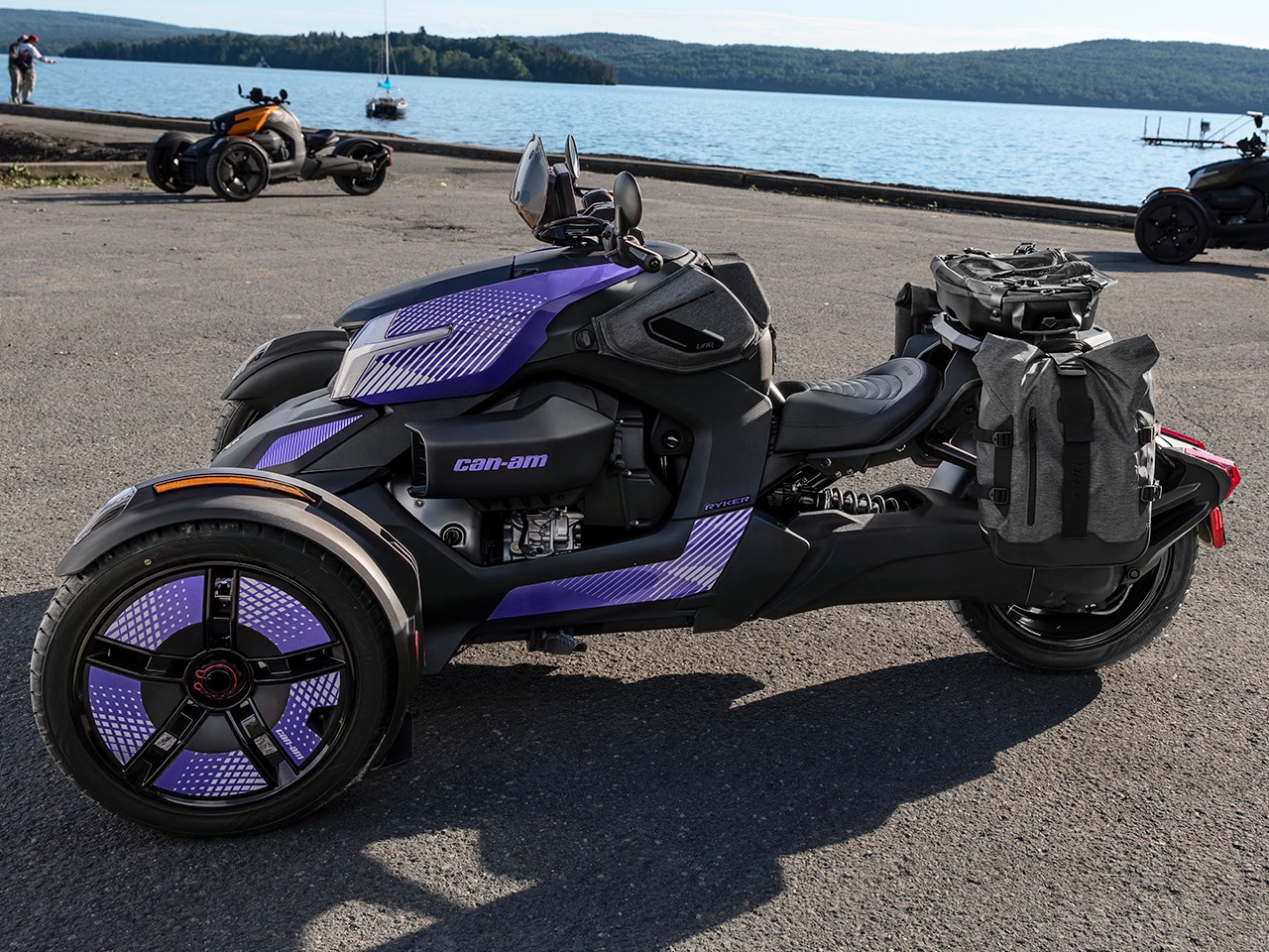 Plusieurs véhicules trois roues Can-Am Ryker 2027 stationnés près d’un lac